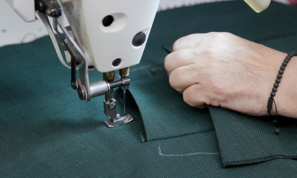 Artisan hand sewing a jacket seam