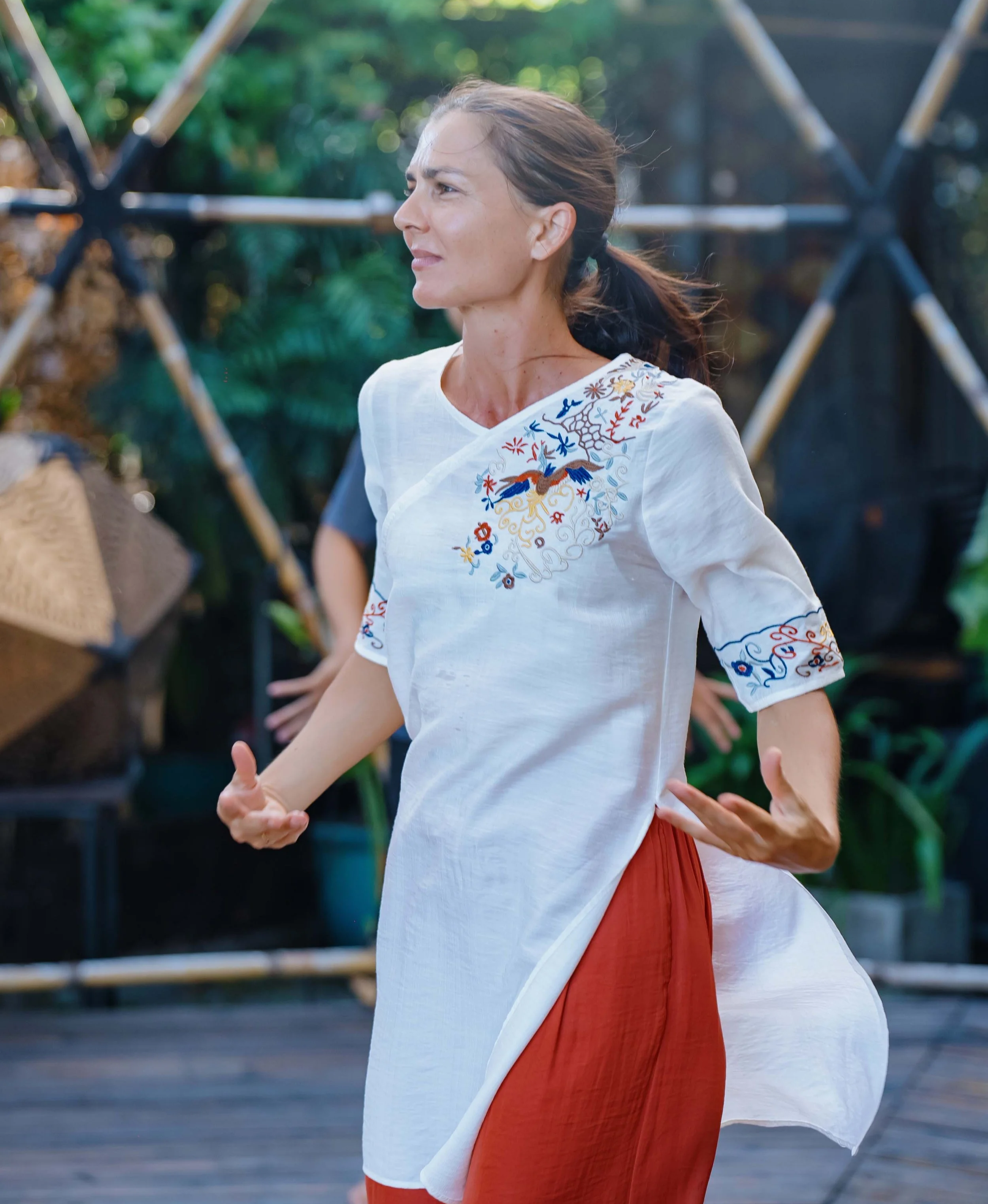 Ani Petrova practicing Taoist Qi Gong while wearing a traditional Vietnamese Áo Dài during a retreat in Vietnam.