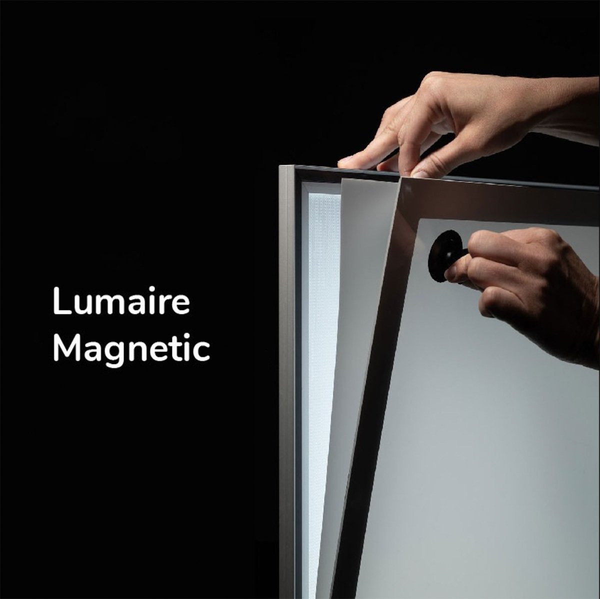 Kuvassa käsi kiinnittää magneettista led paneelia kehykseen. Taustaväri on musta ja teksti lukee "Lumaire Magnetic".
