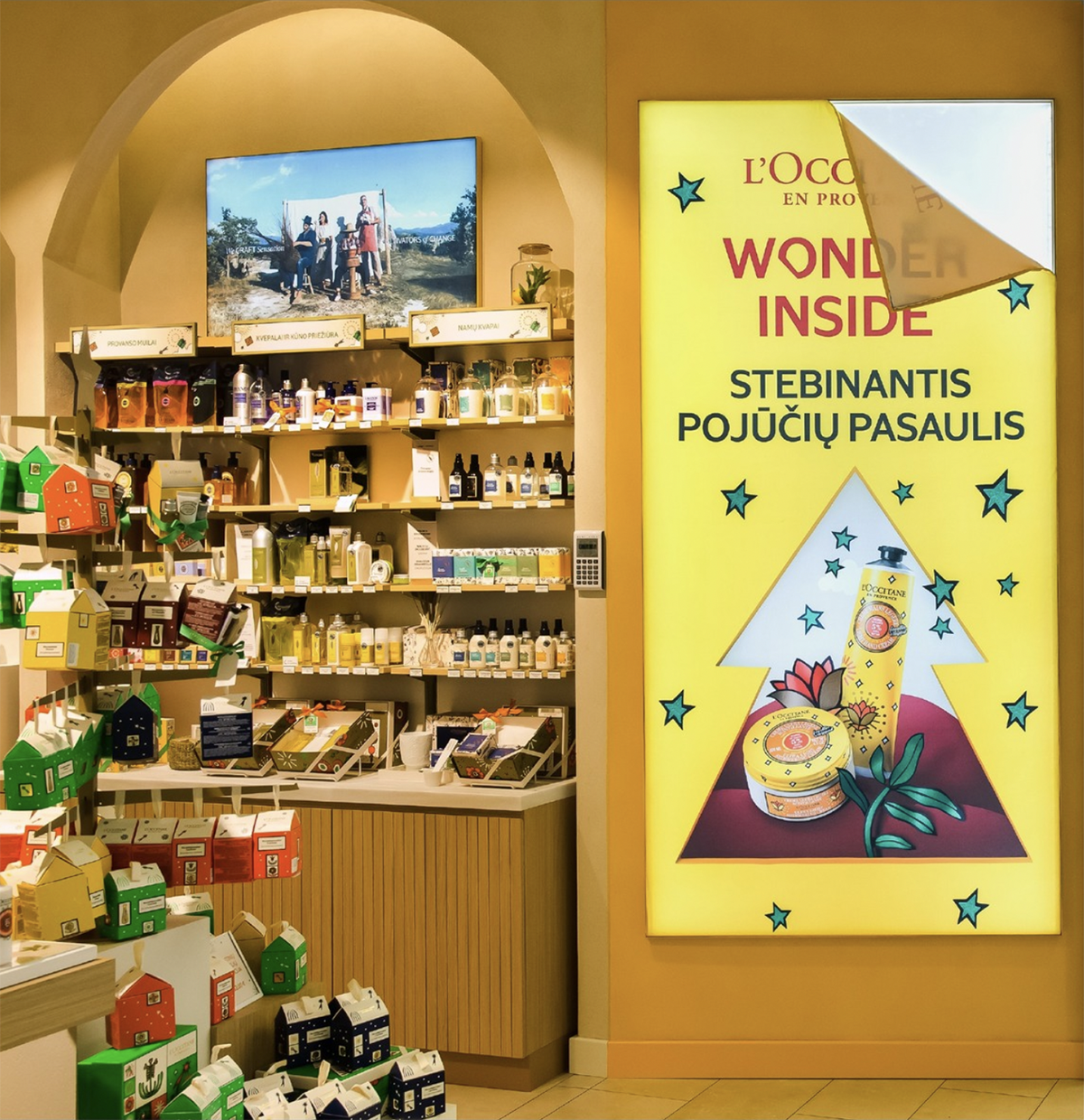 Näkymä kosmetiikkamyymälään, missä on etualalla keltainen led paneelinäyttö.