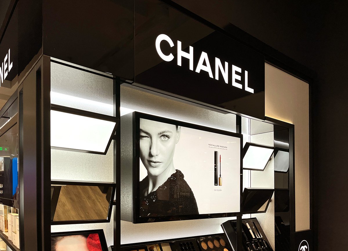 Lähikuva Chanel shopista, jossa on led paneeleja, kuvia ja kosmetiikkatuotteita.