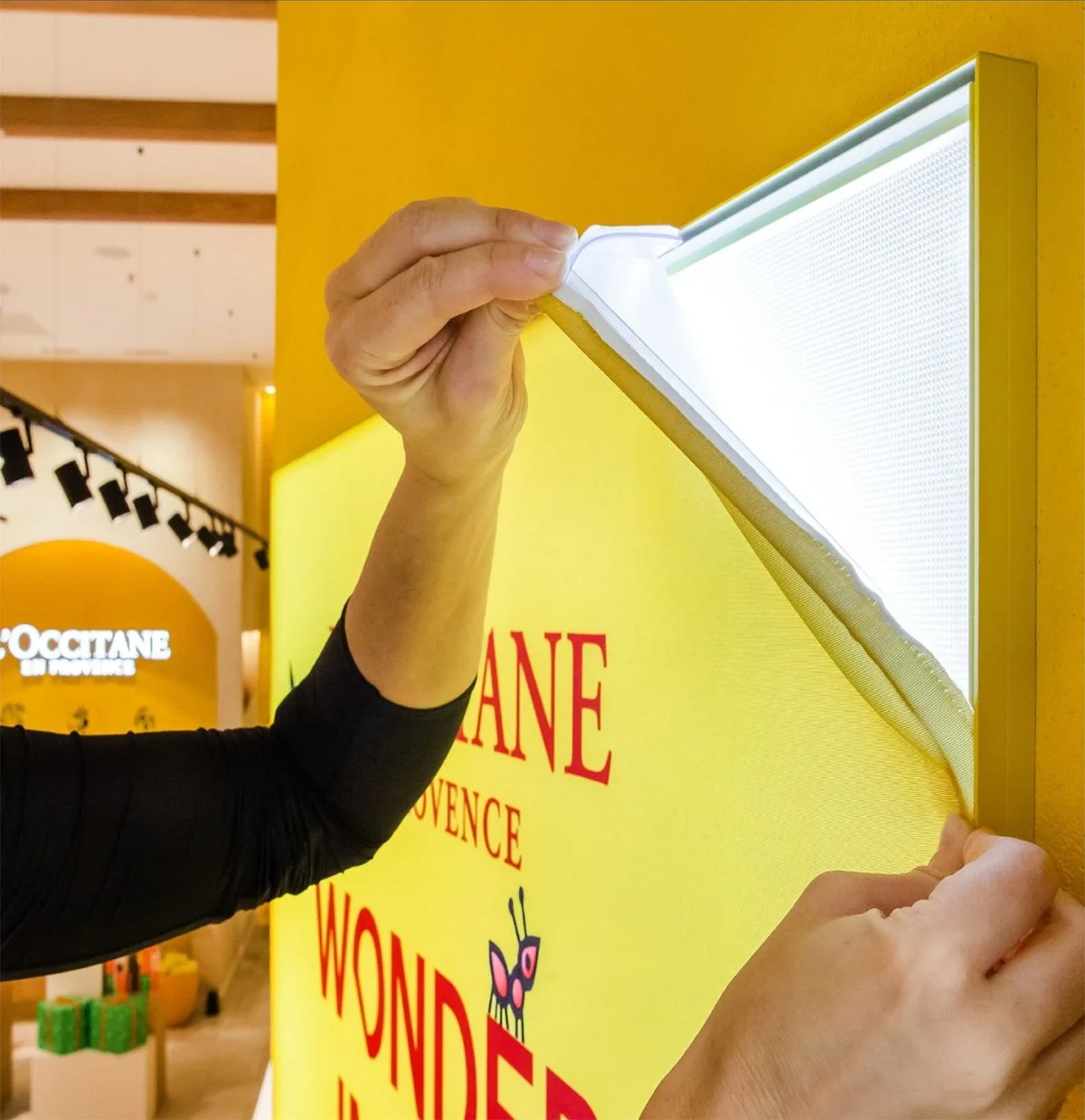 Kuvassa kädet kiinnittävät led paneelia näyttöön. 