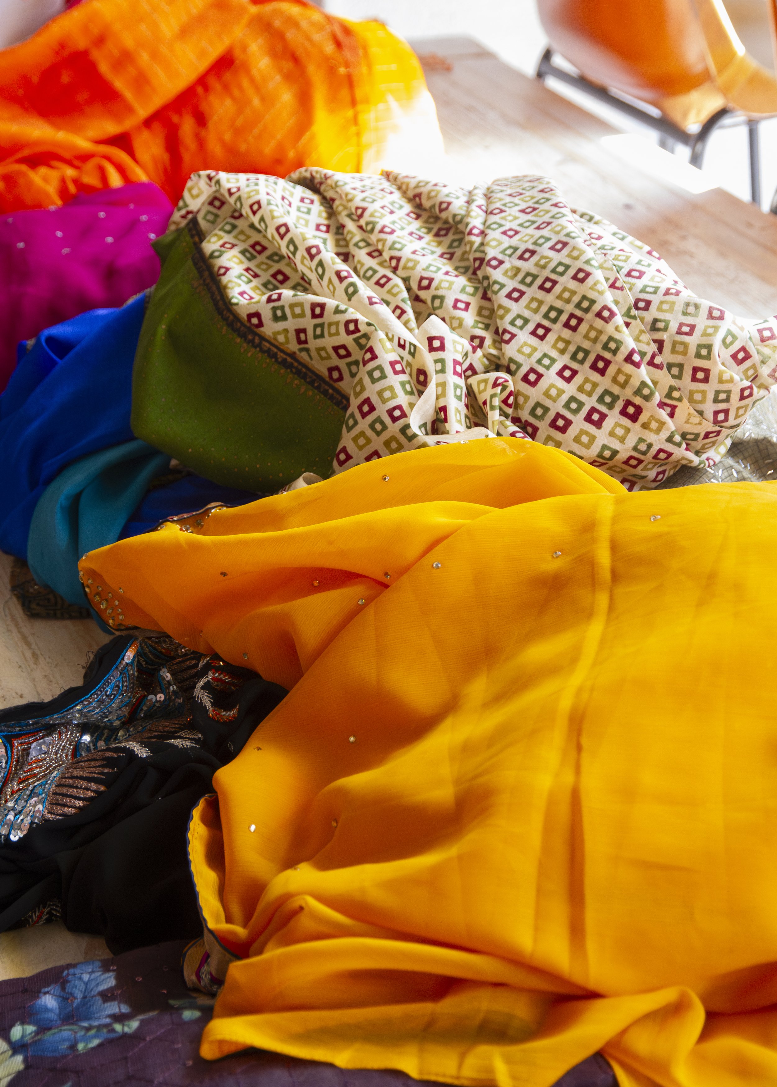A pile of colourful sarees laying on a table