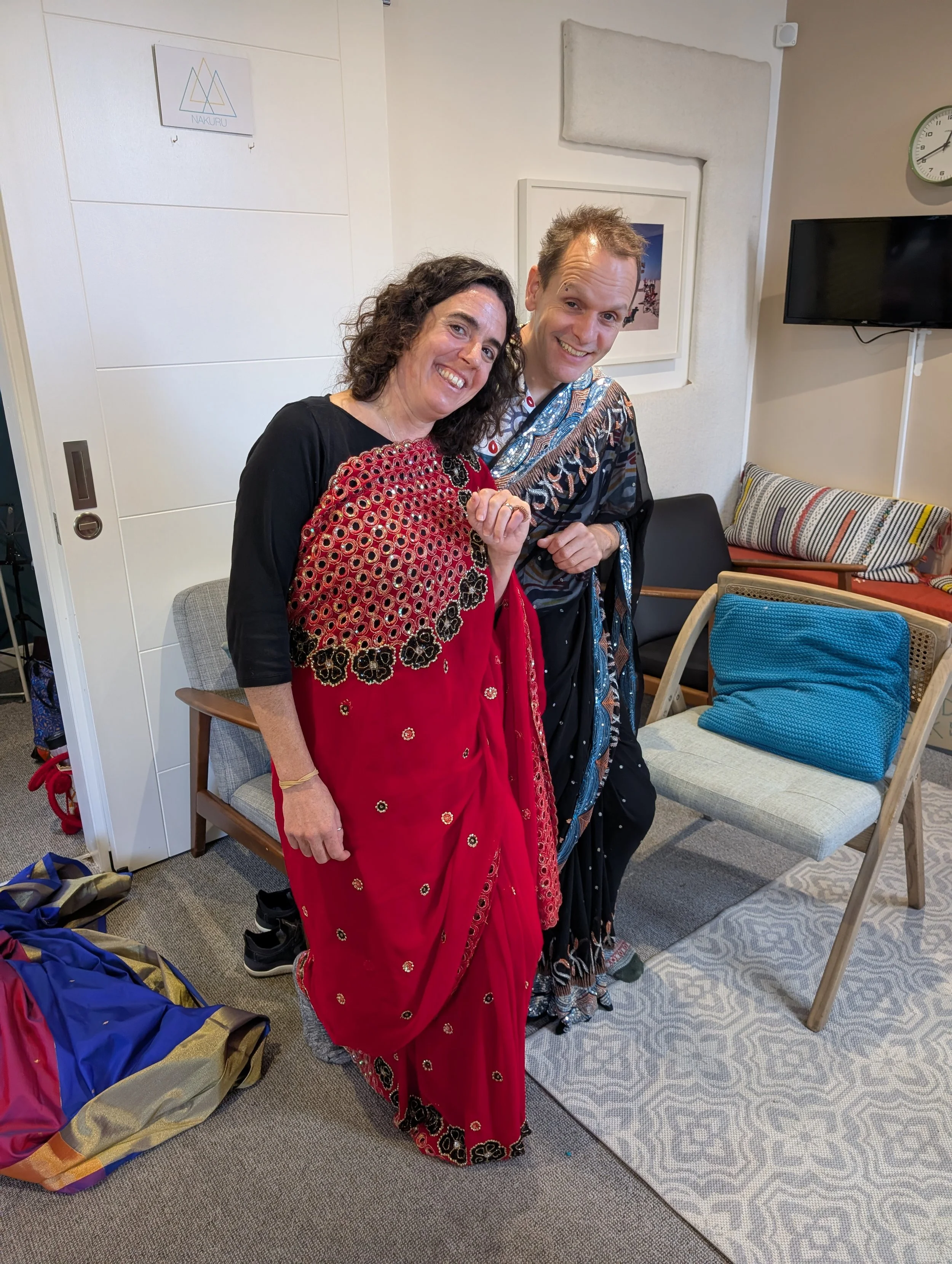 Two people draped in the nivi drape smile and stand close together