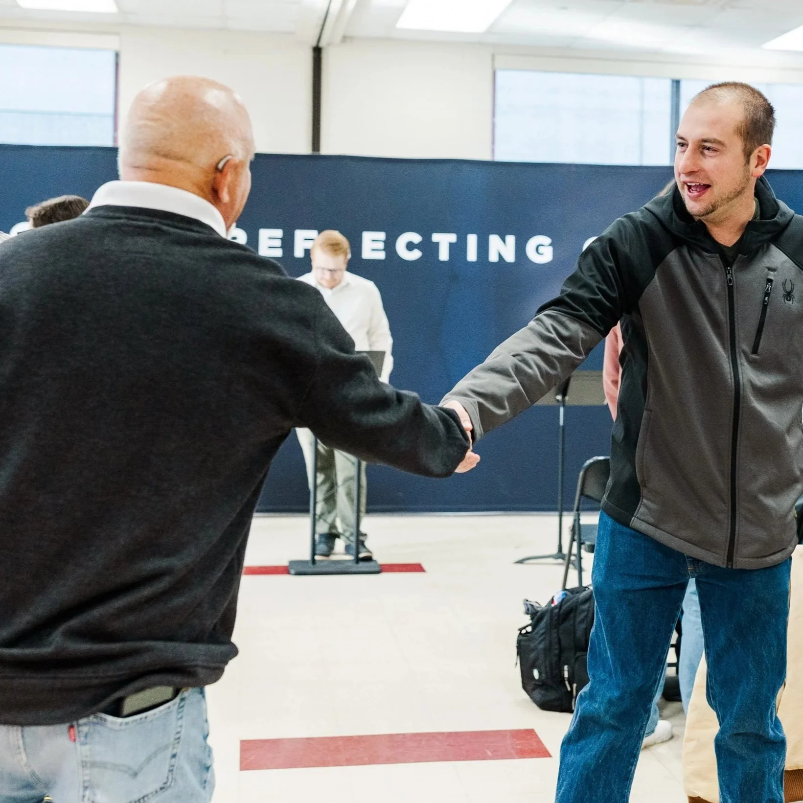 Two men greeting during church service in New Castle, Indiana at the YMCA