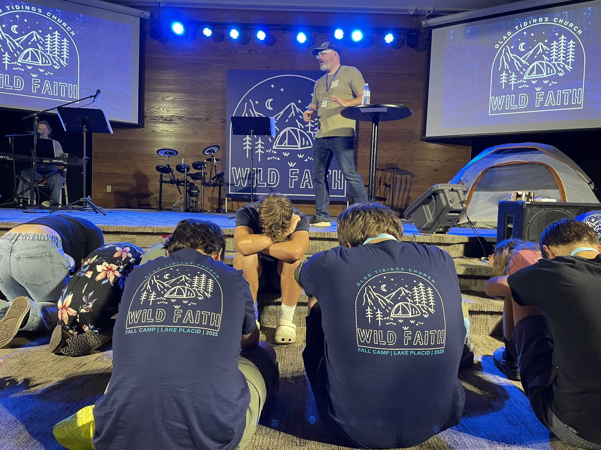 Students and youth praying around the altar as the pastor preaches and shares. 