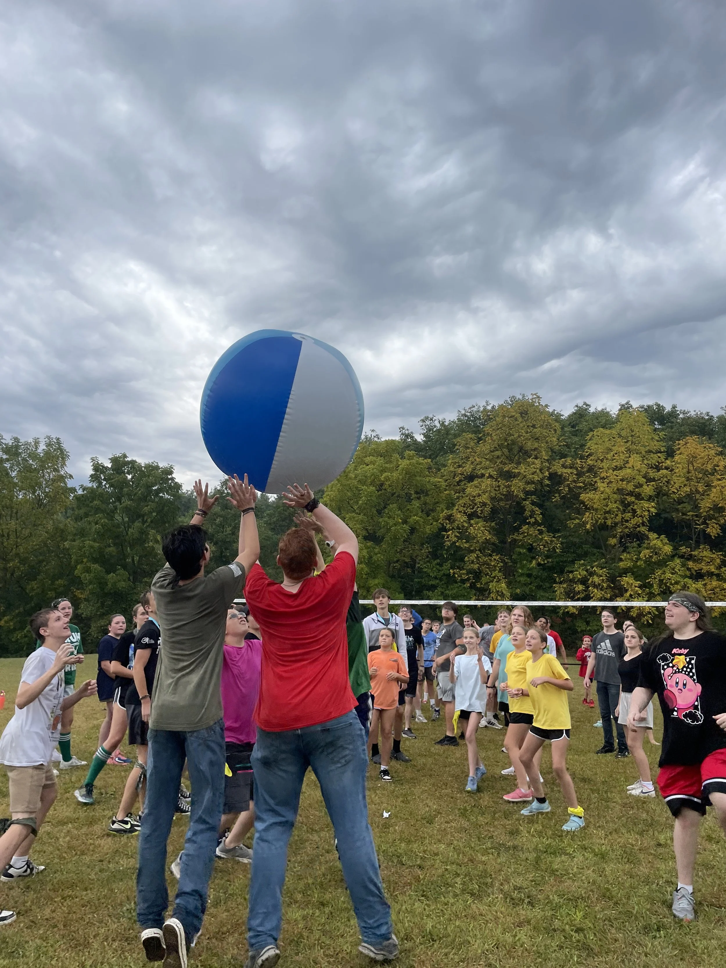 Students and youth play a game of giant volleyball at camp. 