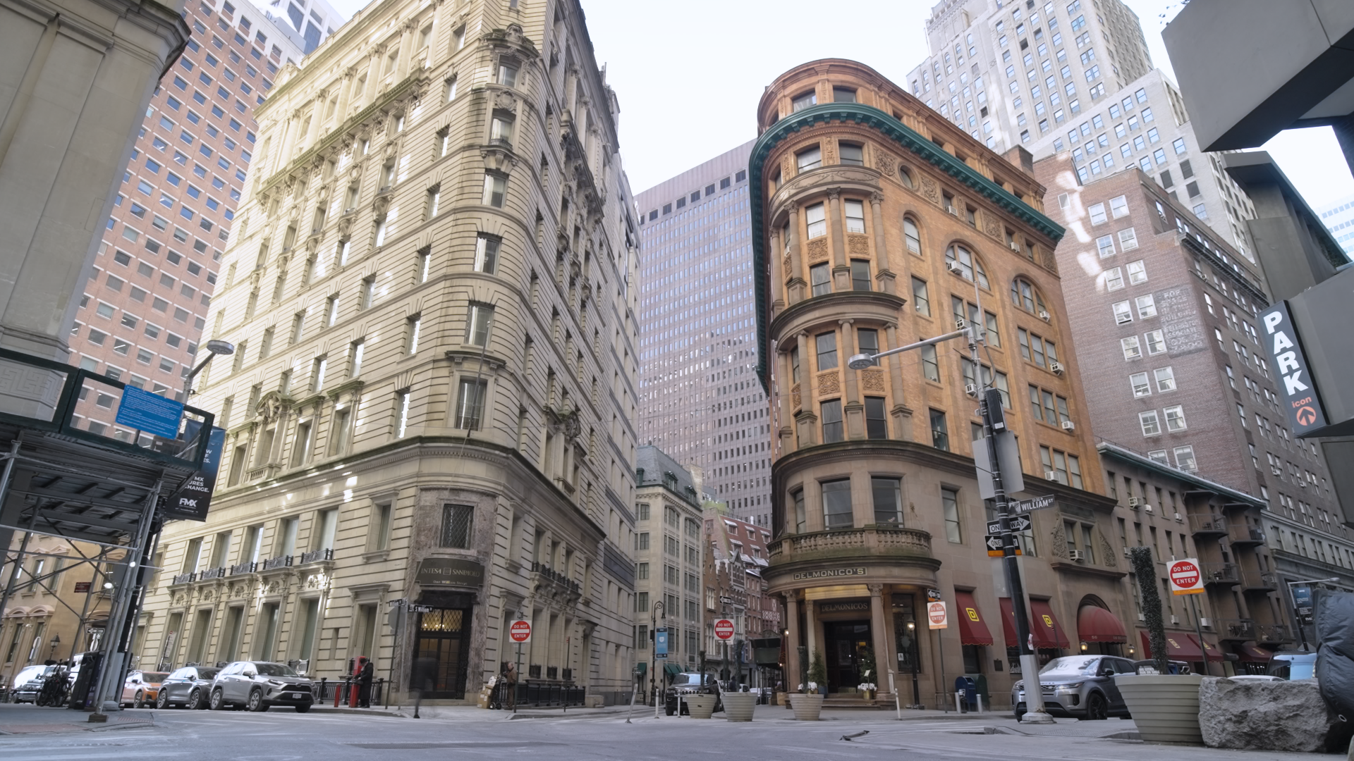 Wide-angle view looking upward at historic buildings in Manhattan's downtown urban area, highlighting detailed architecture, windows, and distinct façades under bright daylight.