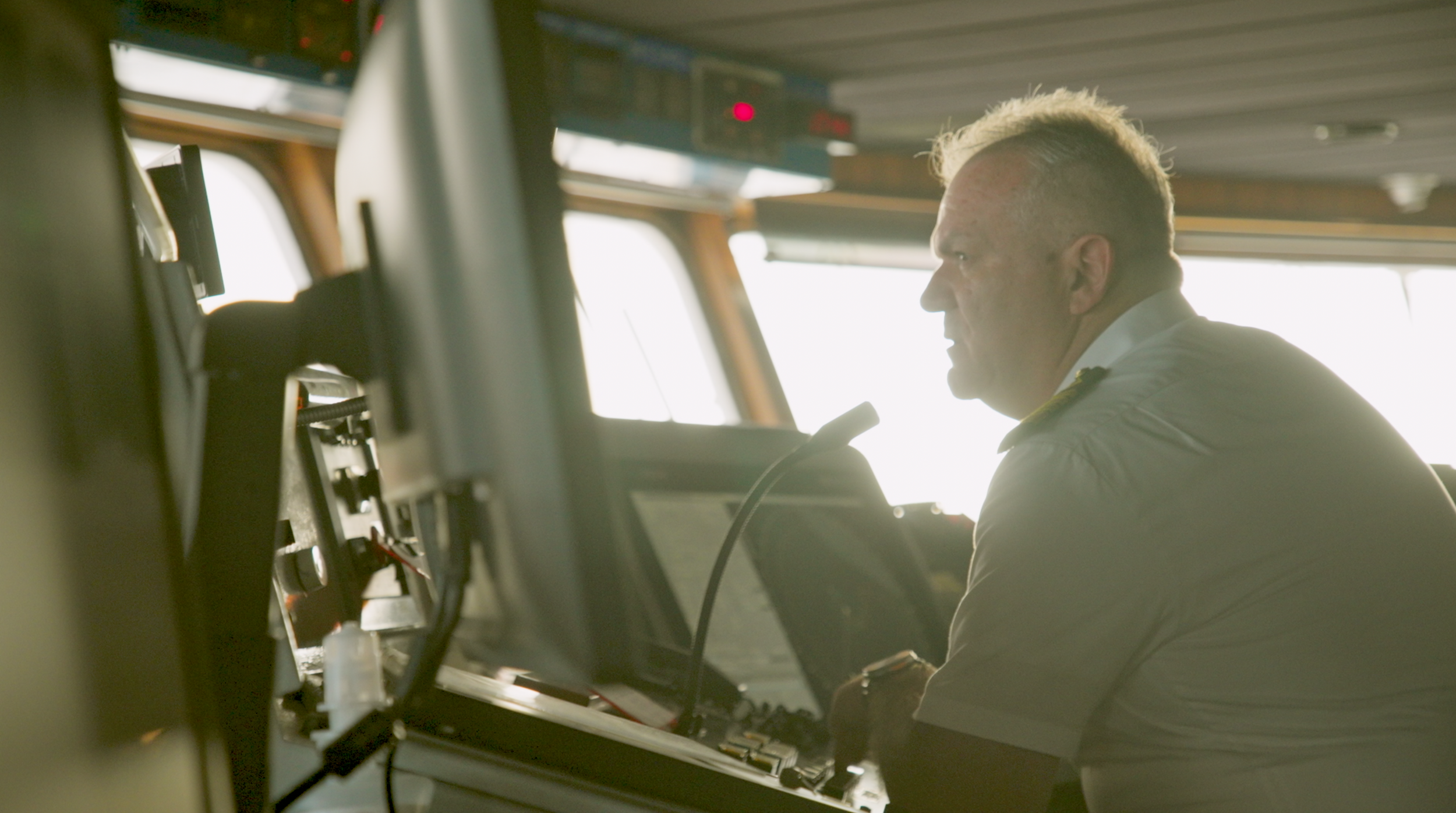 Captain Valentin Giuglea in full uniform with four gold stripes on the upper deck of the MS Odyssey