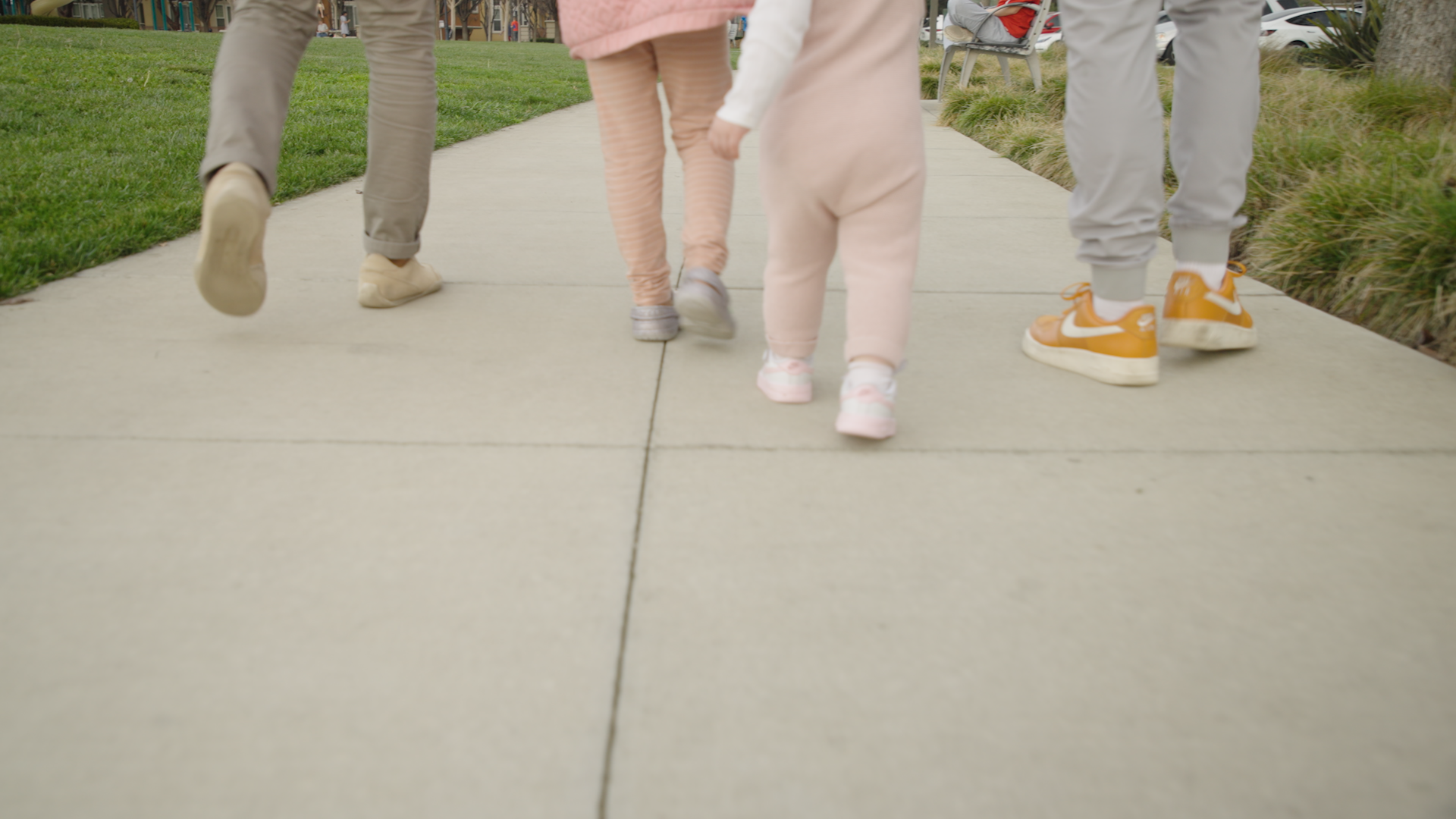 Close-up image of the legs and shoes of entrepreneur Philipp Wehn, his daughter, and friends as they enjoy a leisurely walk outdoors.
