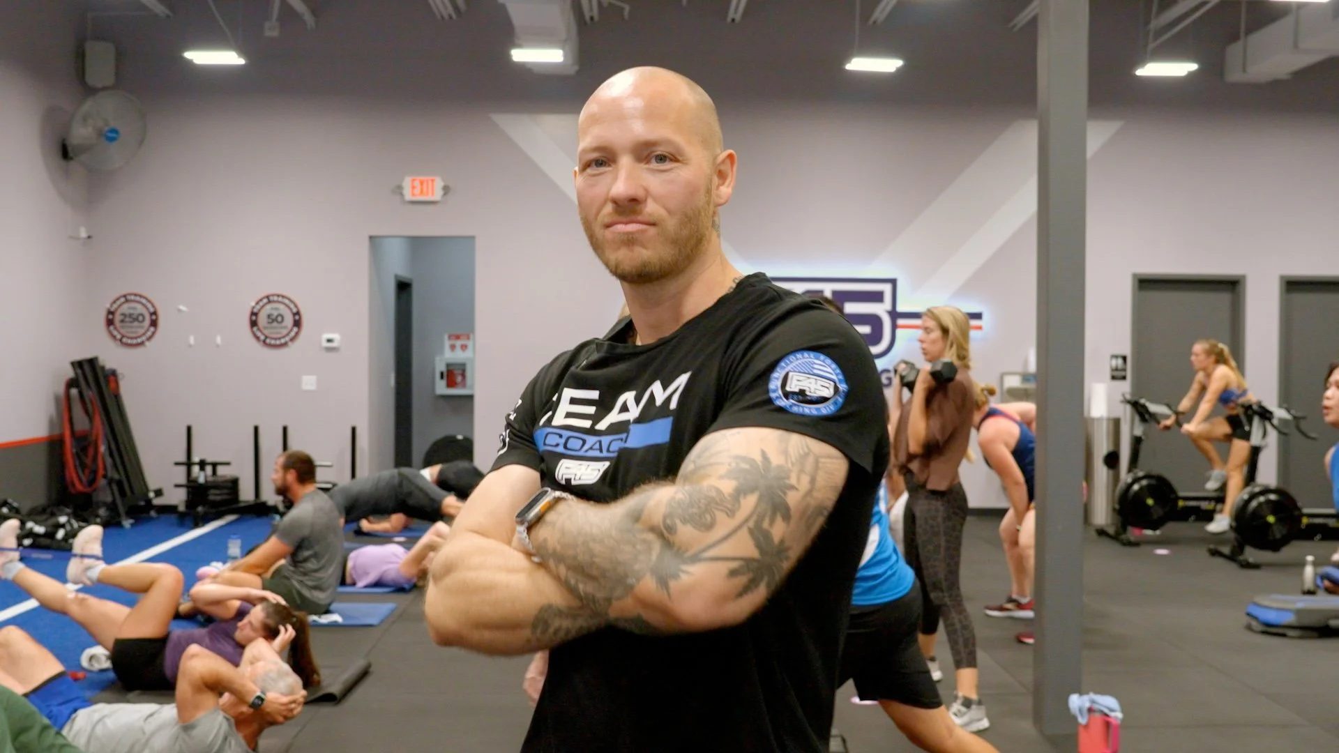 Documentary portrait of Constantin, fitness coach, in F45 training facility with class in background