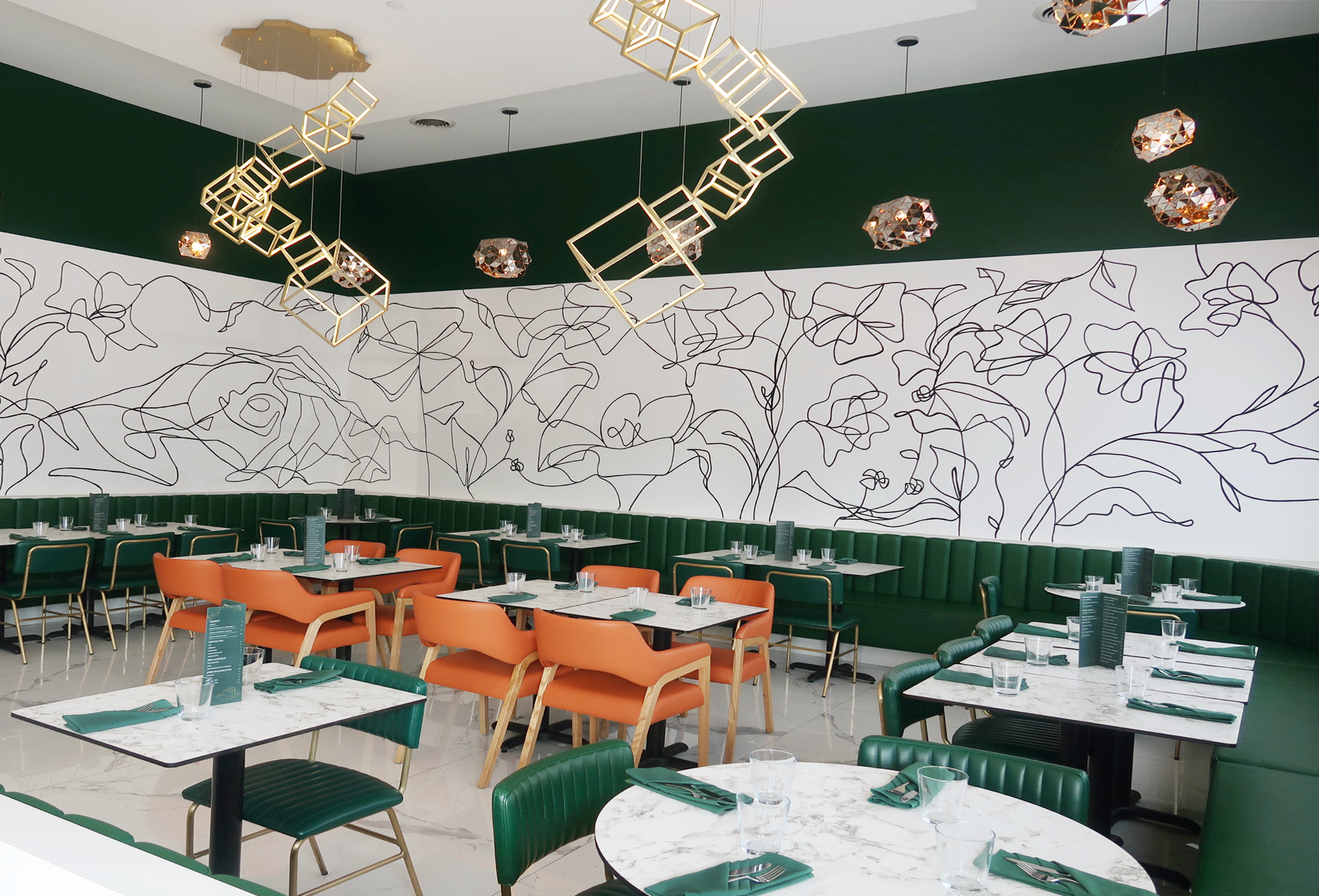 Modern restaurant interior with green and orange chairs, white marble tables, black line floral wall art, geometric pendant lights, and decorative ceiling lights.