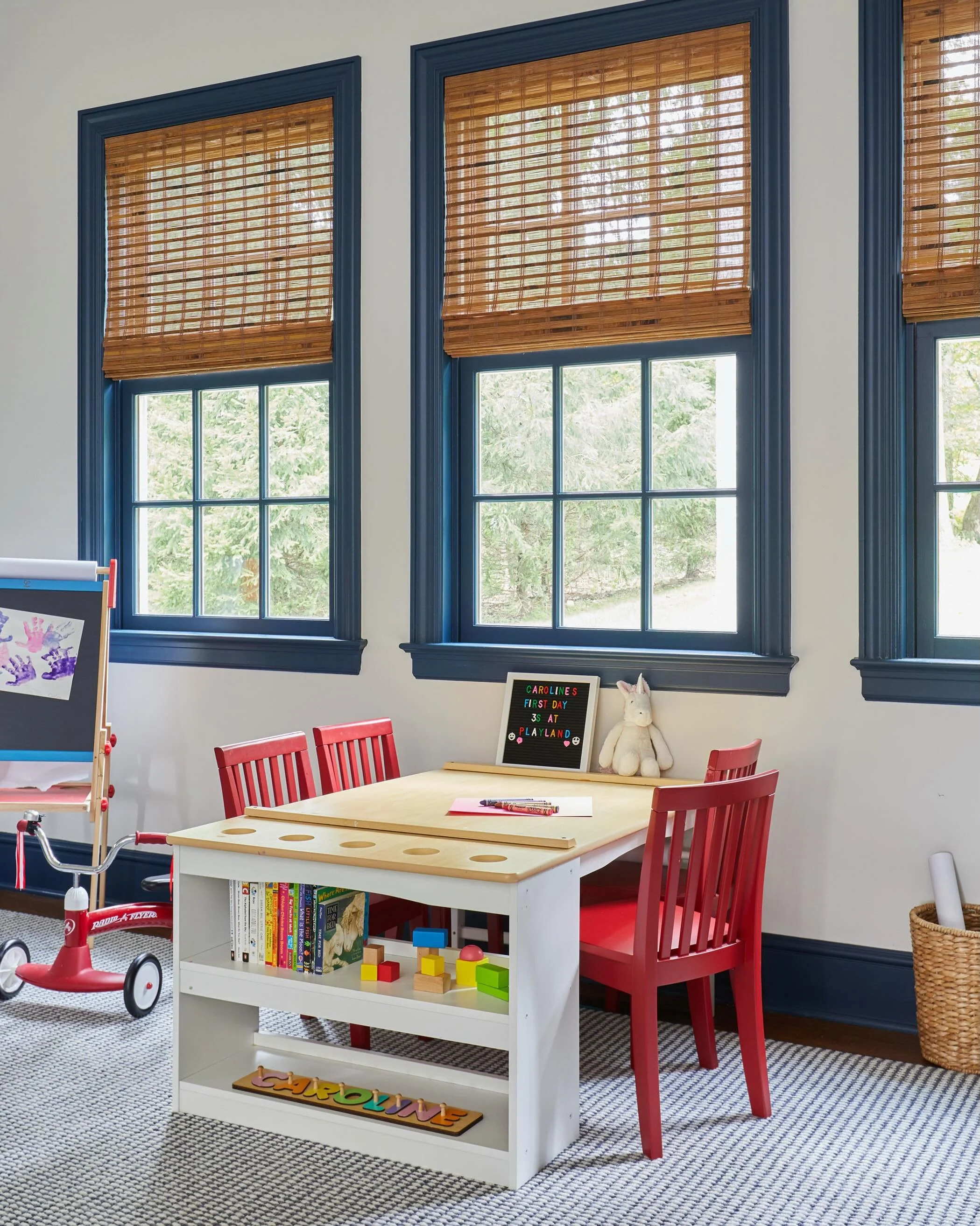 Endless hours to play! Navy accents, warm bamboo shades, and a dedicated art space give this kids&rsquo; playroom classic charm.