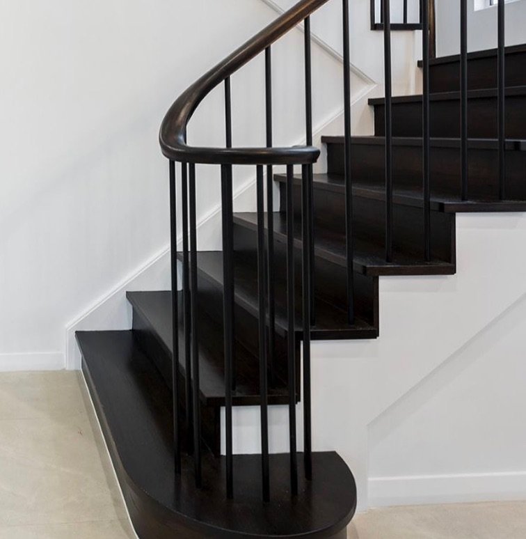 Obsessing over this stair detail! 🖤 This is so chic and takes that builders spec black rod railing  and elevates it.
I would achieve this look through running a black wood stair or even tiled stair that allows the rods to seamlessly blend. 

To know