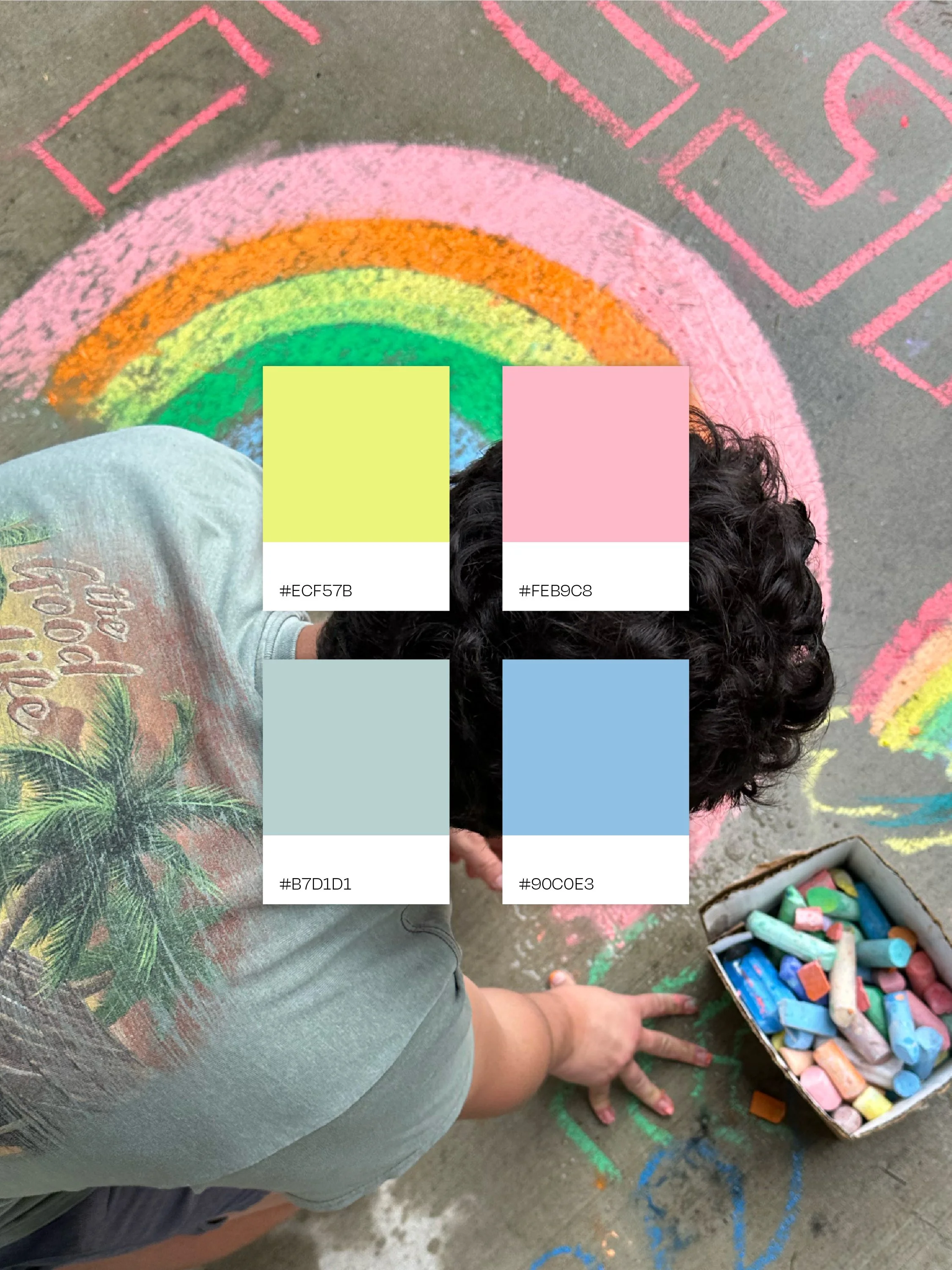 Colorful sidewalk chalk drawings in pink, blue, and orange on a driveway