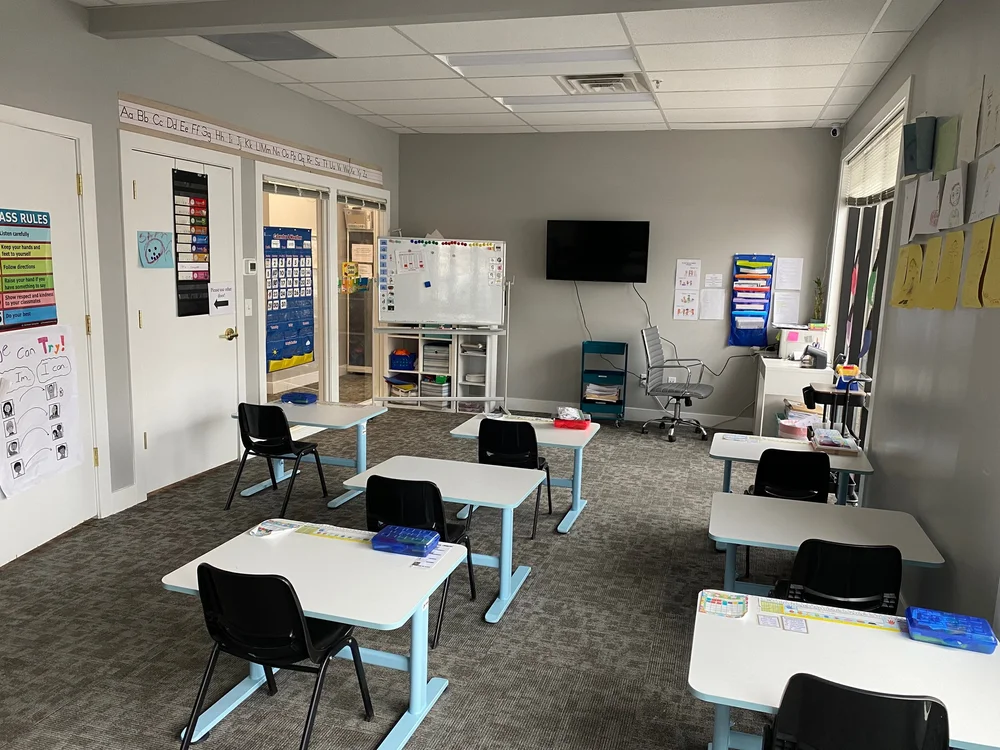 Thrive Learning Center classroom at NBCG with small desks and learning materials