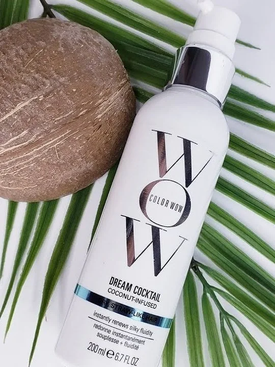 Color WOW Dream cocktail products laying next to coconut on leaft