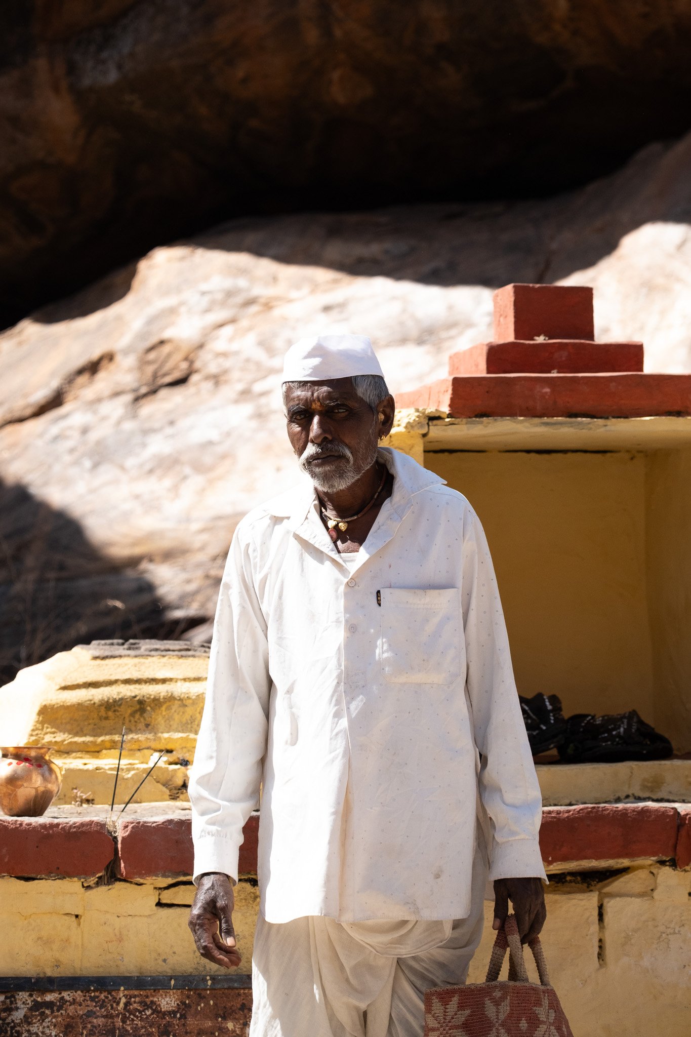 A Hindu man climbs up the hill to to pray at the temple within the sandstone. 
