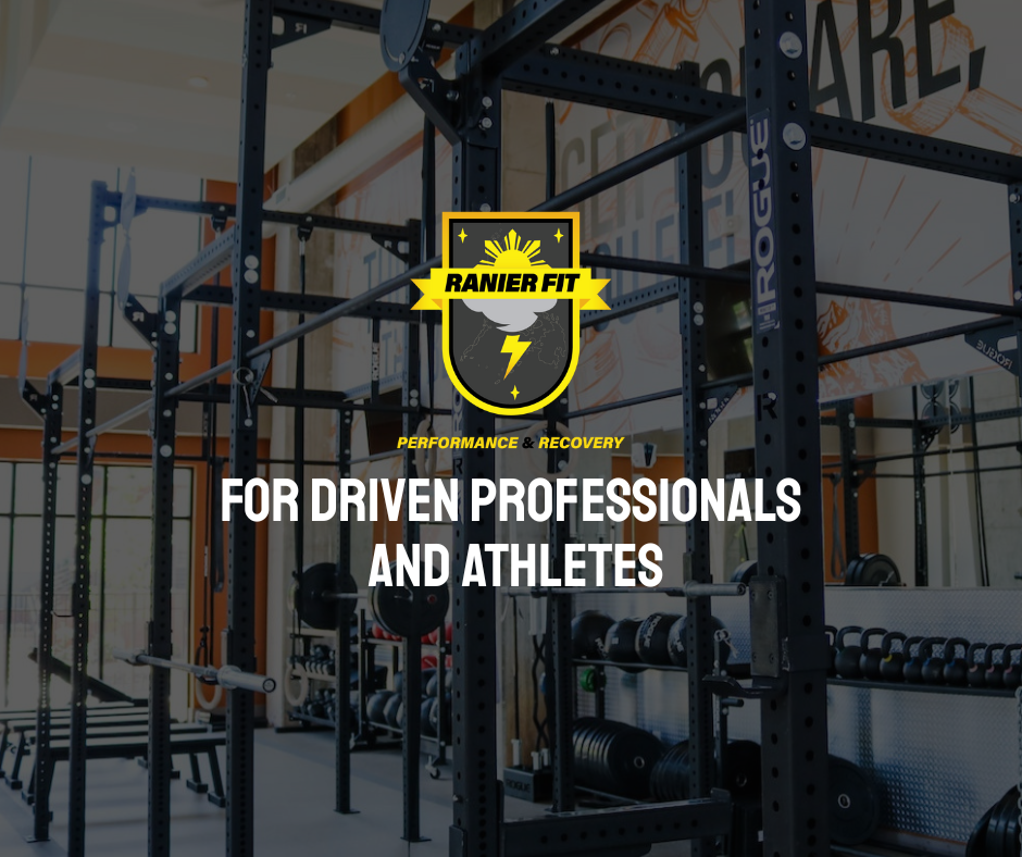 Interior of a gym with black metal workout racks, weights, and exercise equipment, with a logo that reads "Ranier Fit" and team slogan "Performance & Recovery" blanketing the space.
