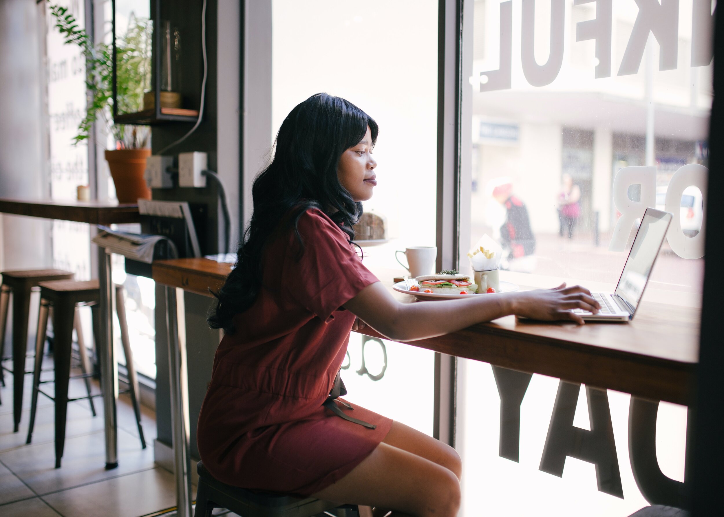 woman-in-red-dress-using-laptop-on-table-1112796.jpg