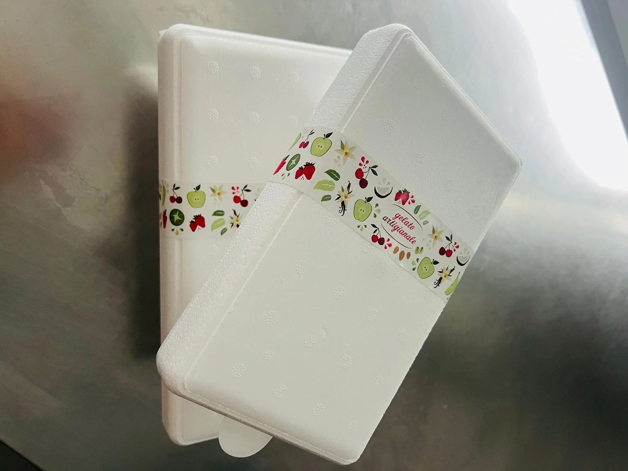 Två vita gelékladdiga bakverk med dekorativa band med fruktmotiv.