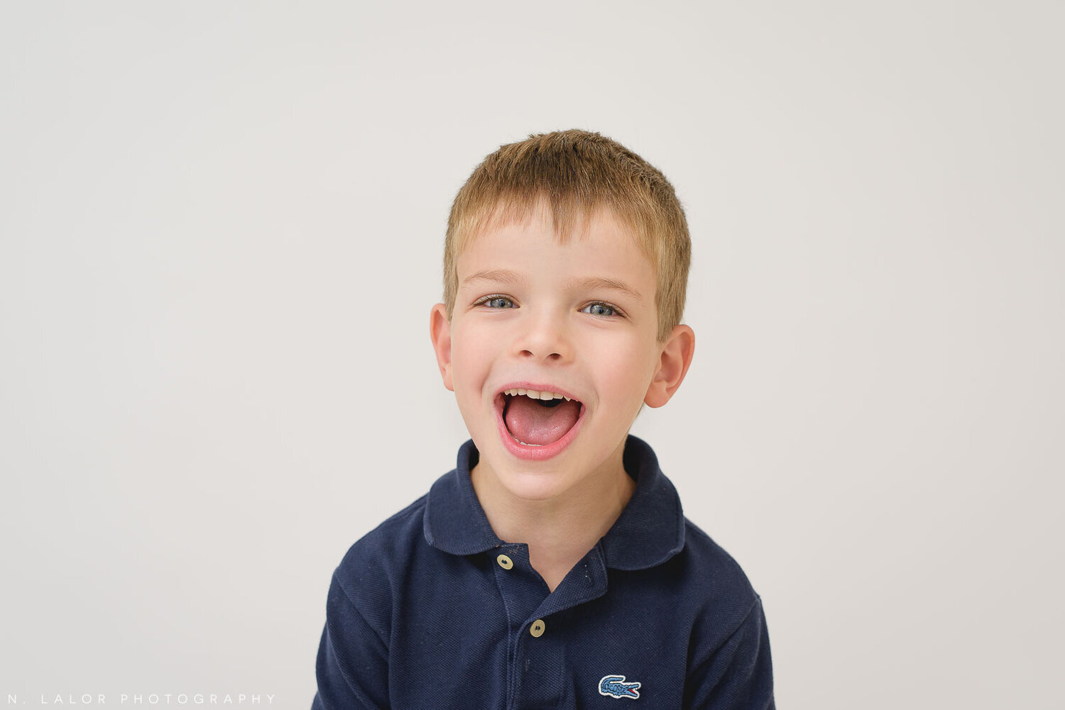 Boy making a silly face for a photo. Family Studio photo session by N. Lalor Photography in Greenwich Connecticut.