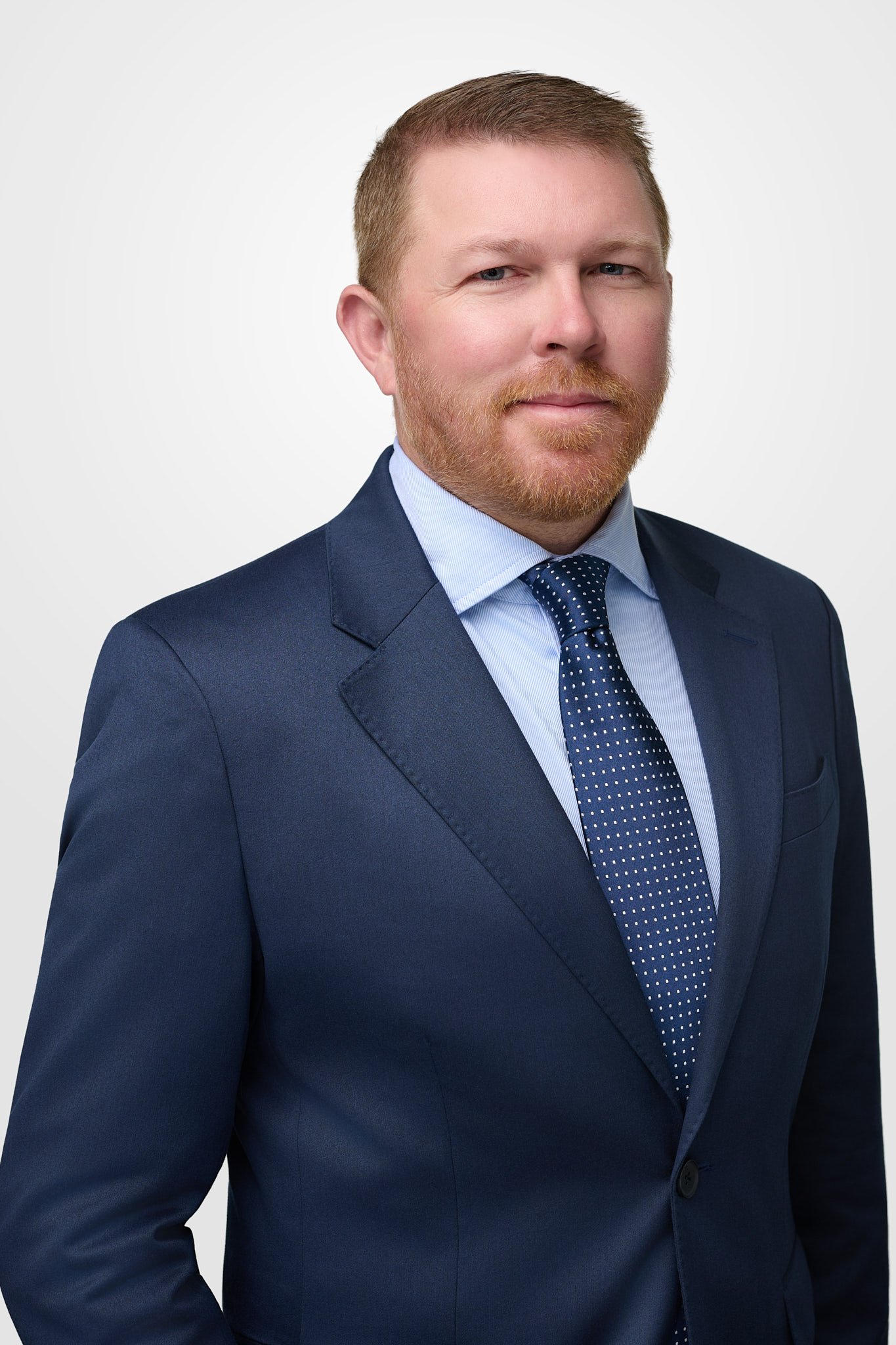 Professional corporate headshot of a businessman in a navy suit and patterned tie, taken at N. Lalor Photography’s studio in Westport, CT.