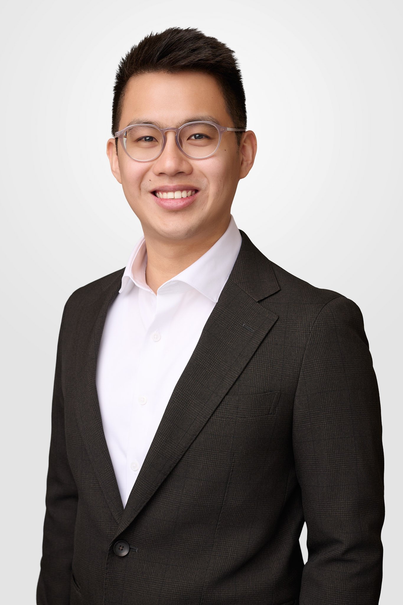 Modern business headshot of a man with glasses and a dark grey suit, professional photography services in Fairfield County, CT.