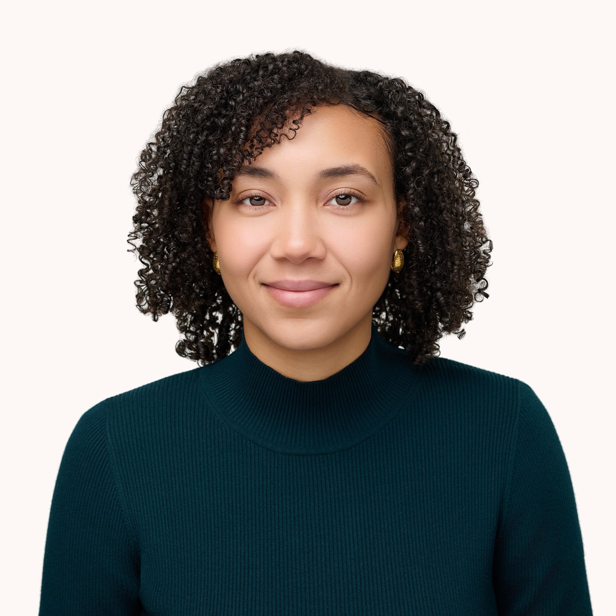 Studio headshot of a woman with curly hair wearing a teal turtleneck, high-quality professional portrait by N. Lalor Photography, Westport, CT.
