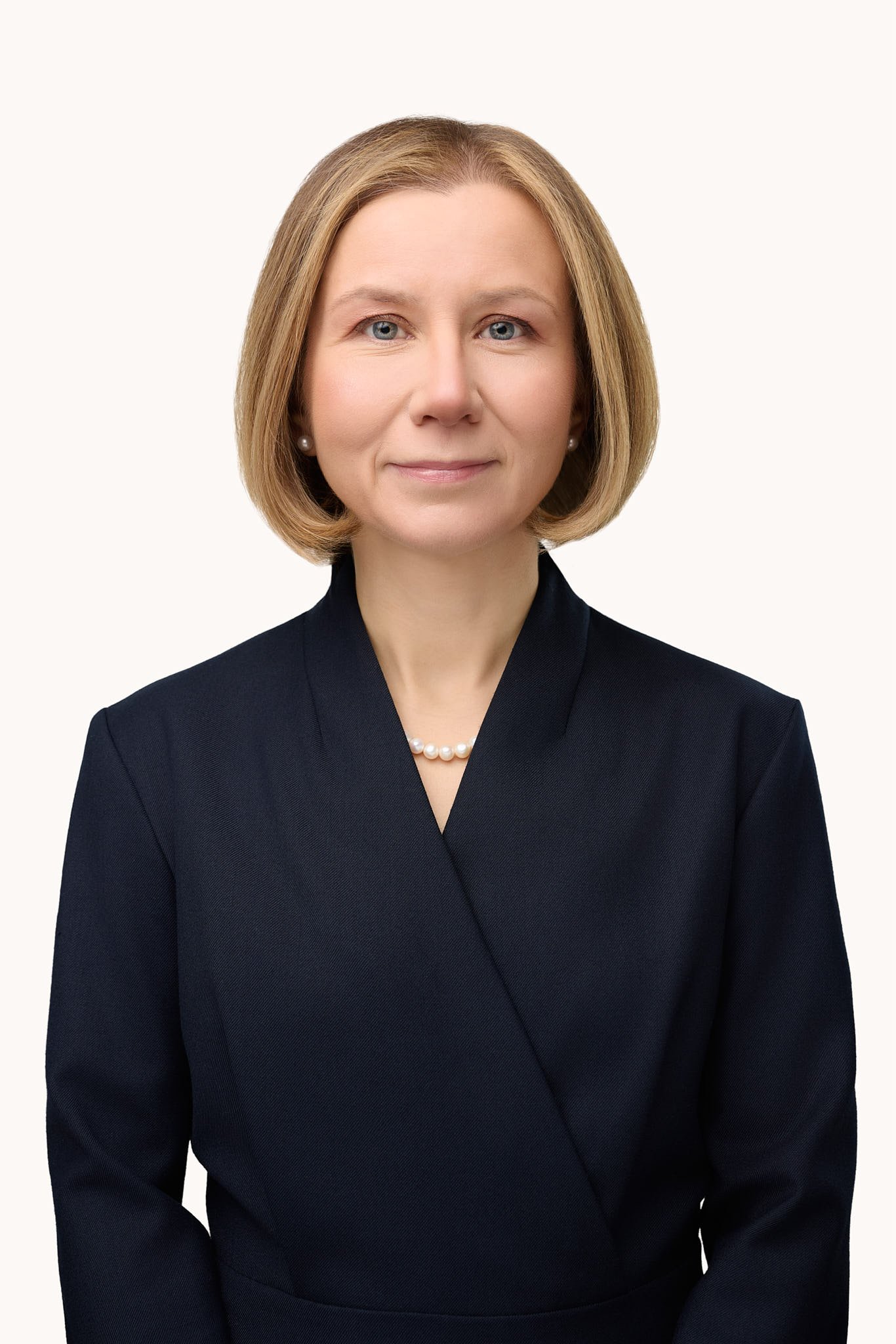 Professional studio portrait of a female private wealth advisor in a dark suit with pearl necklace by Westport headshot photographer.