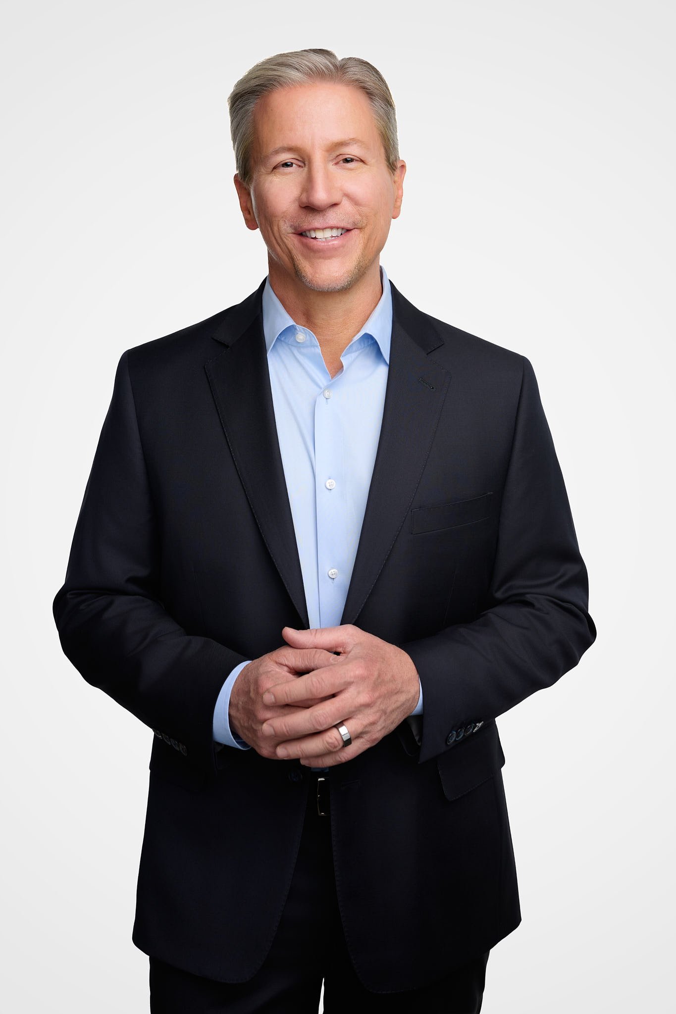 Approachable lawyer portrait of a man in a navy suit and light blue shirt, professional studio headshot by N. Lalor Photography.