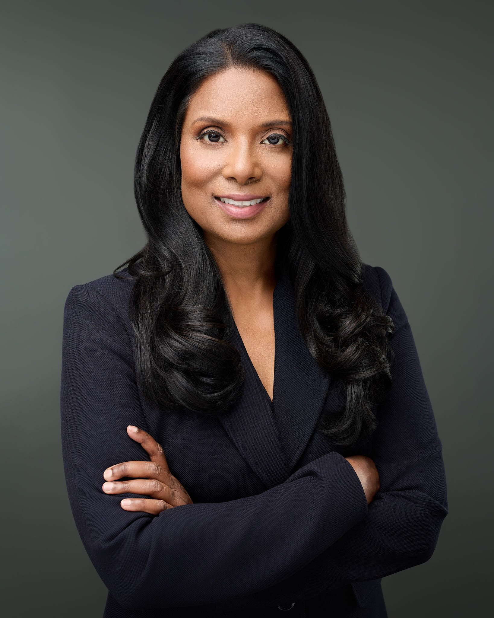 Professional executive headshot of a woman with long dark hair in a navy blazer, captured by N. Lalor Photography in Westport, CT.