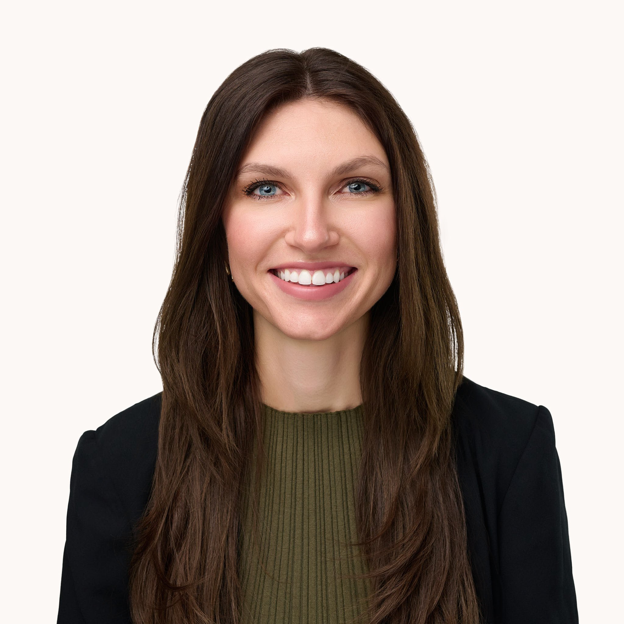 Professional studio headshot of a smiling woman in a green top and black blazer, Fairfield County CT business portrait by N. Lalor Photography.