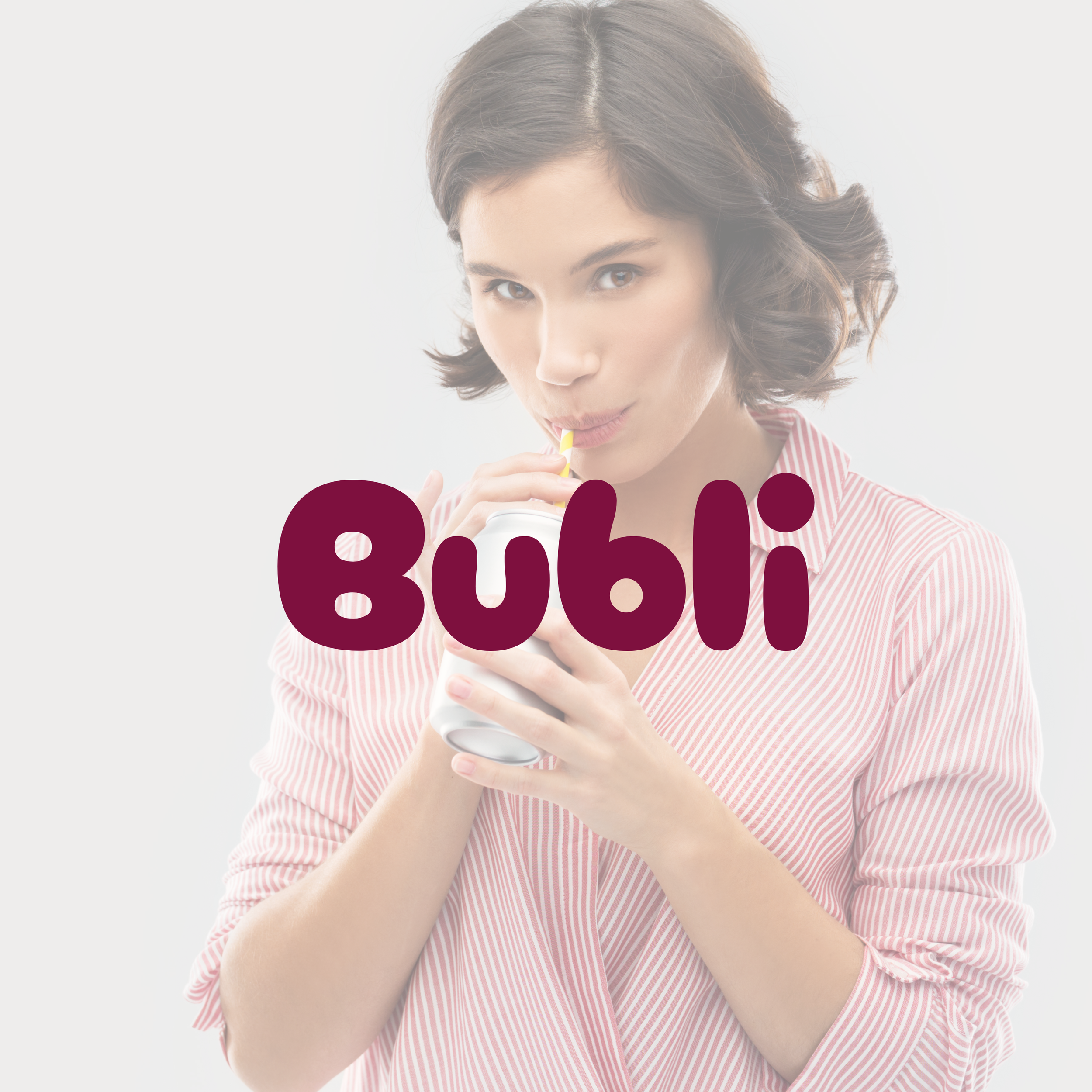 Woman drinking from a can with a yellow straw, wearing a striped shirt. Text "Bubli" is overlaid on the image.