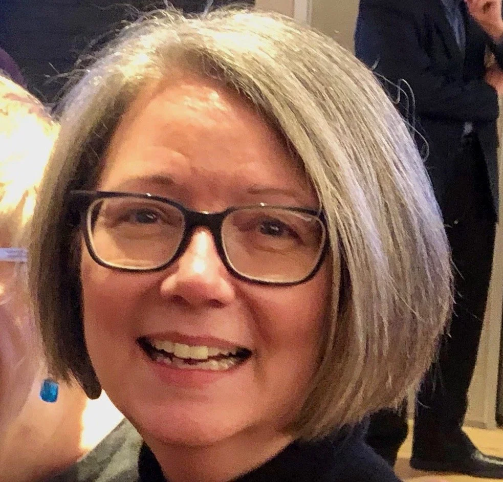 Monica Snellings Inquiring Minds' co founder  with short, blonde hair and black glasses.