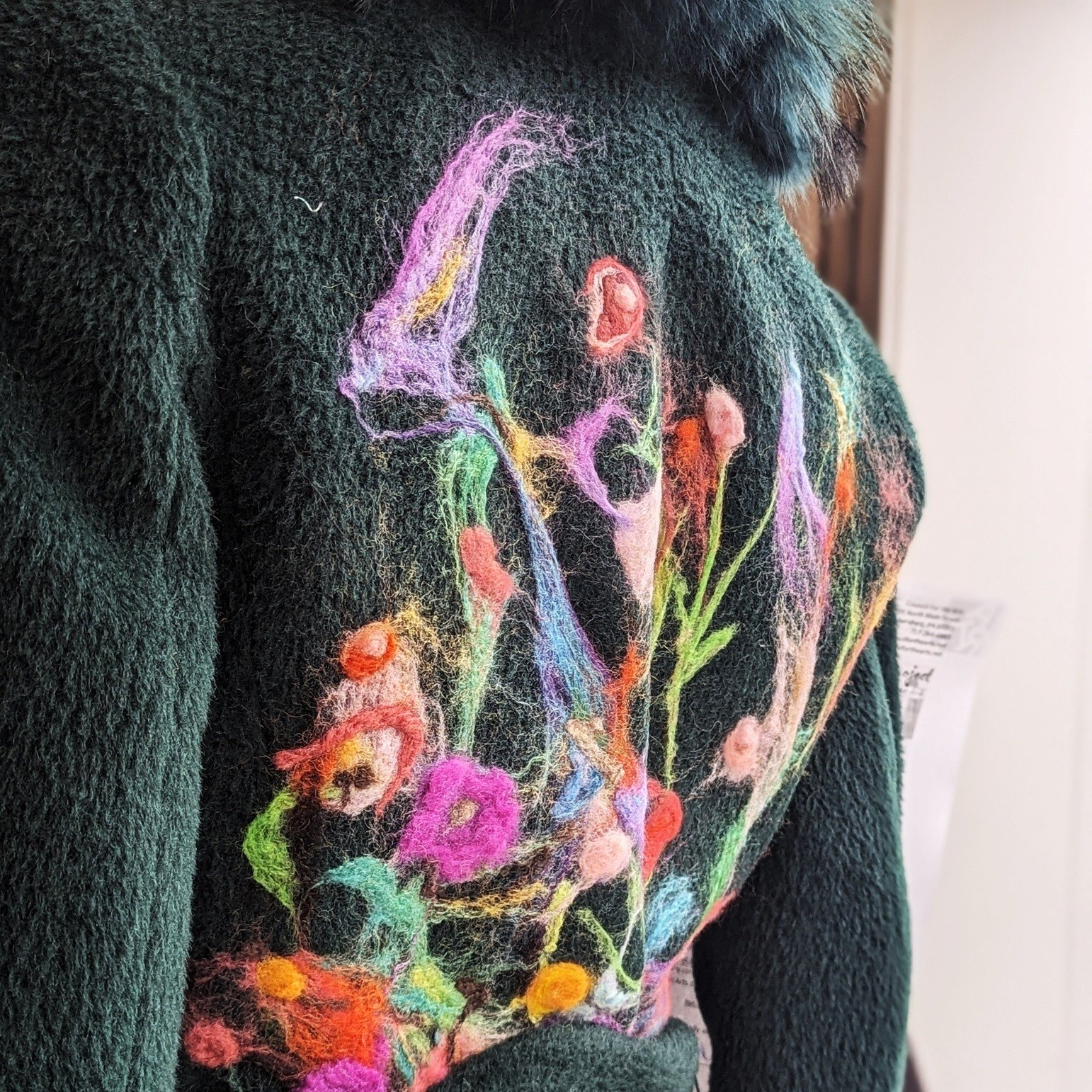 Colorful felted wool creates a magical garden on a green alpaca wool coat with a real fox collar. Coat donated by Nancy Sabiston and transformed by local artist Carolyn Baker, this coat will be available for auction. Or buy now! Come by to see where 