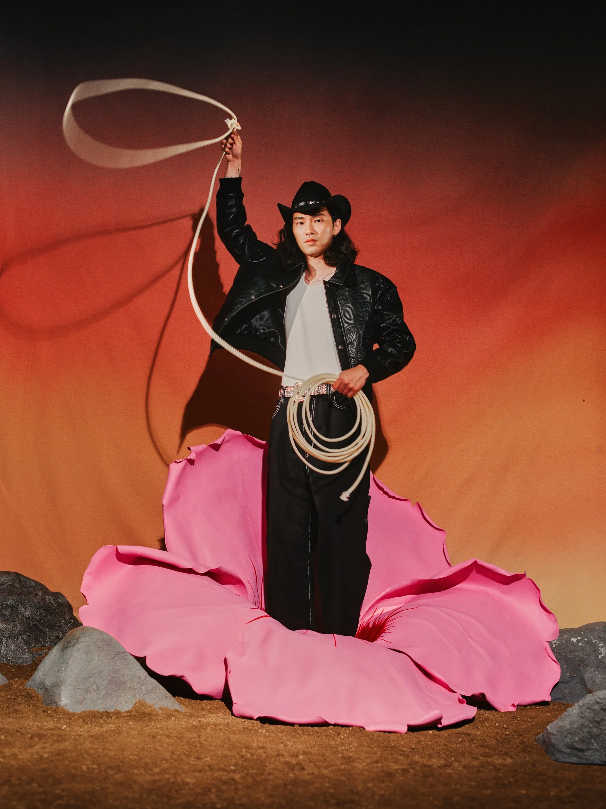 Borrowing from Sandro Boticelli’s The Birth of Venus, an enlarged mugunghwa (무궁화), the national flower of South Korea, serves as a platform for the emergence of our figurine dressed in western wear and throwing a lasso signals the readiness to tackle