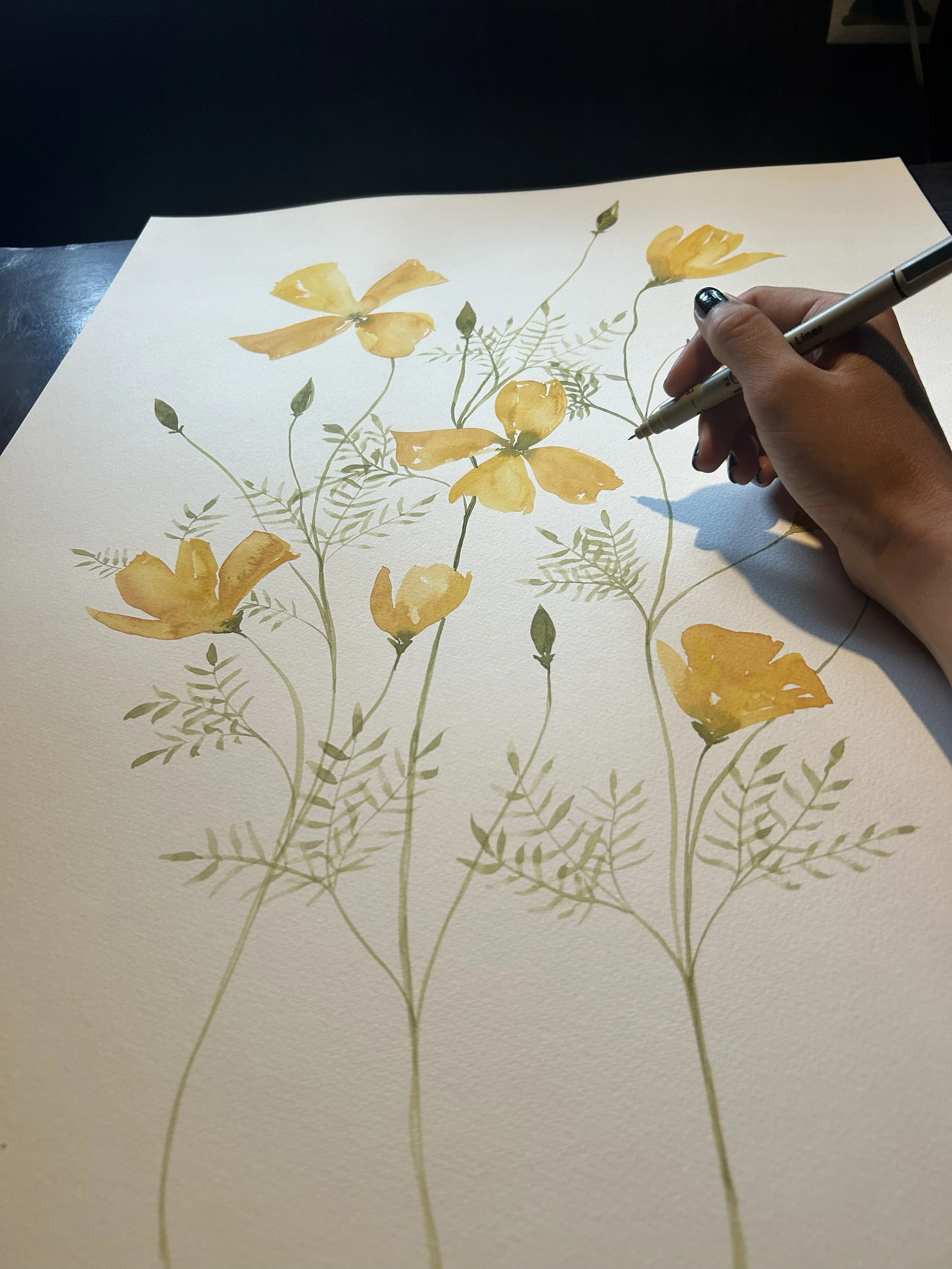 Hand painting yellow flowers and green foliage on watercolor paper.