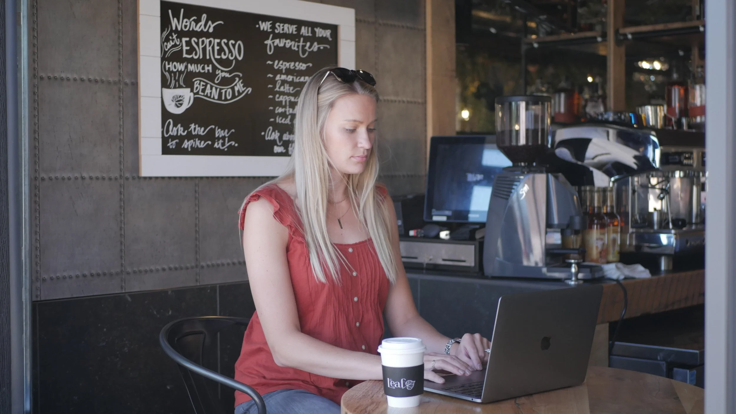 Girl sitting at laptop enjoying coffee at the leaf