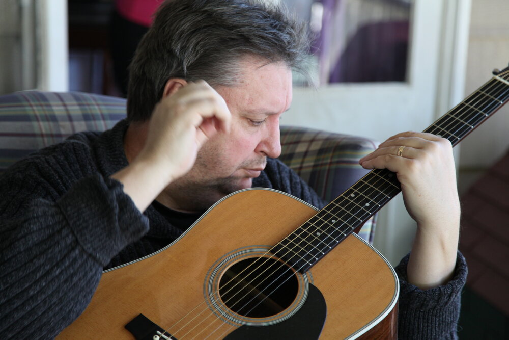 Jeremy playing acoustic guitar. MAIN STILL copy.jpg