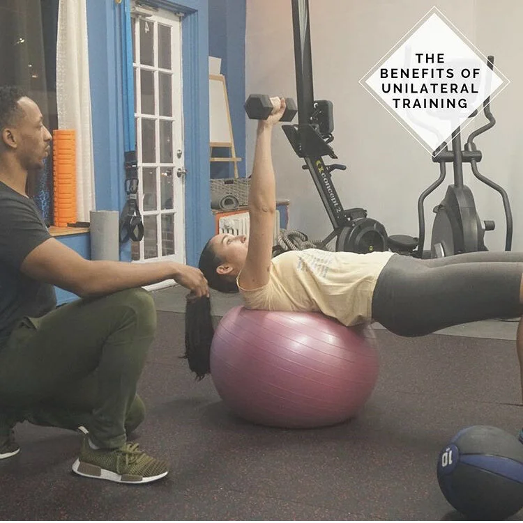 Personal trainer coaching a client through a unilateral stability ball exercise