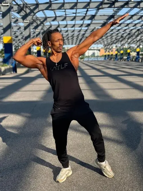 Head personal trainer at Rooted Fitness Collective posing outdoors in athletic gear.