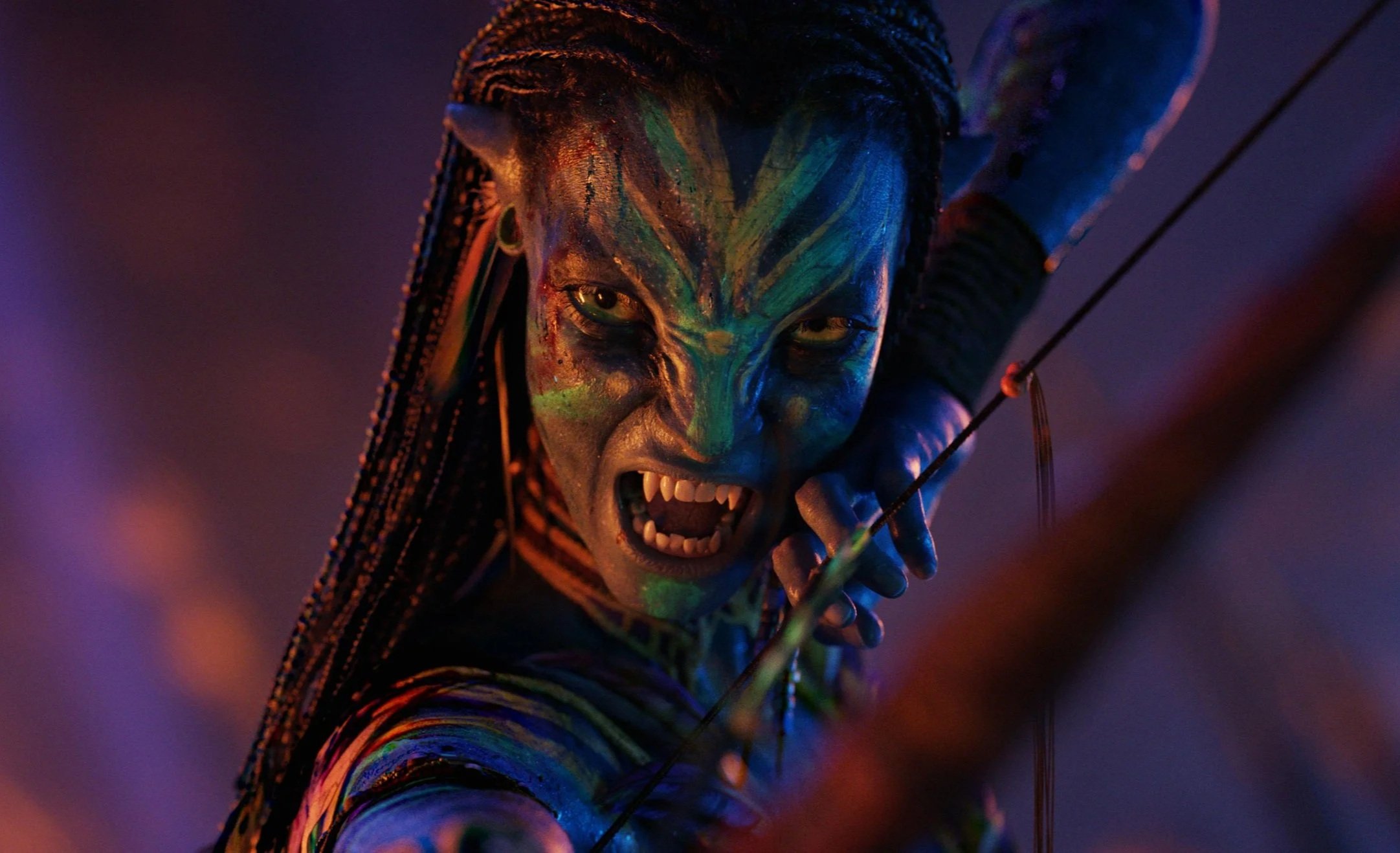 Avatar Fire And Ash Still: A Navi, painted with vibrant tribal makeup, snarling and holding a bow and arrow, with an intense expression.