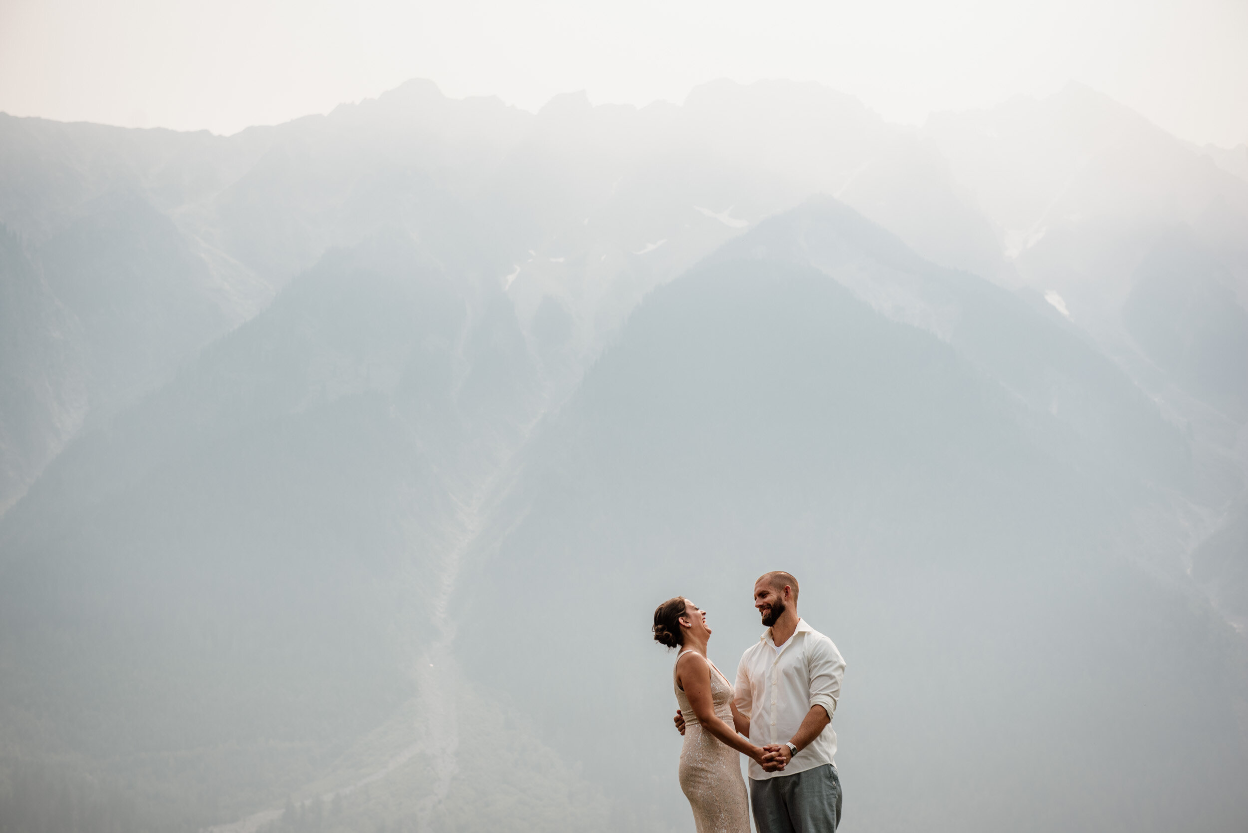 Portrait of bride and groom at Big Sky Golf Course in Pemberton in front of Mount Currie with smokey sky