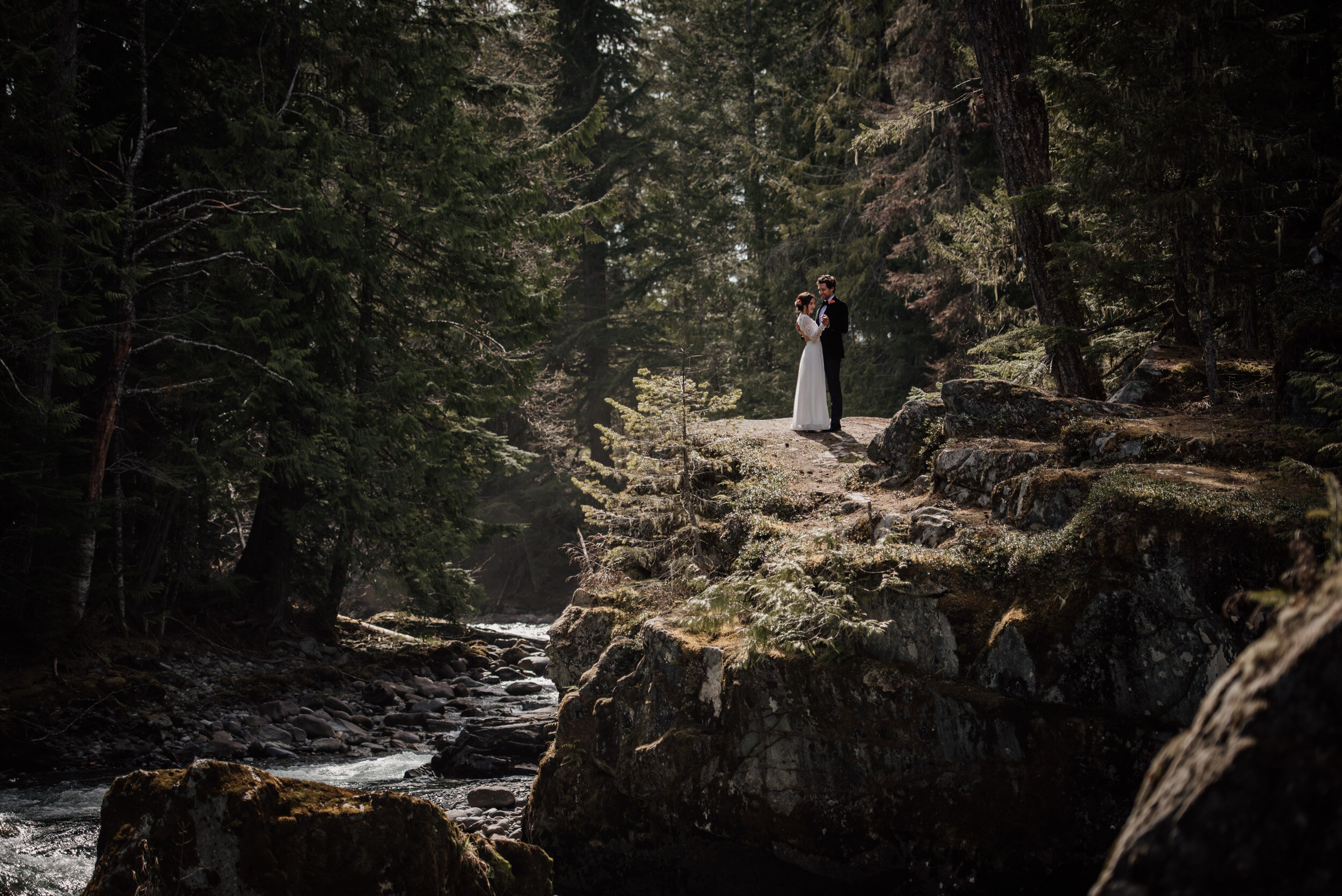 Dramatic portrait of bride and groom in the forest by the river in Whistler