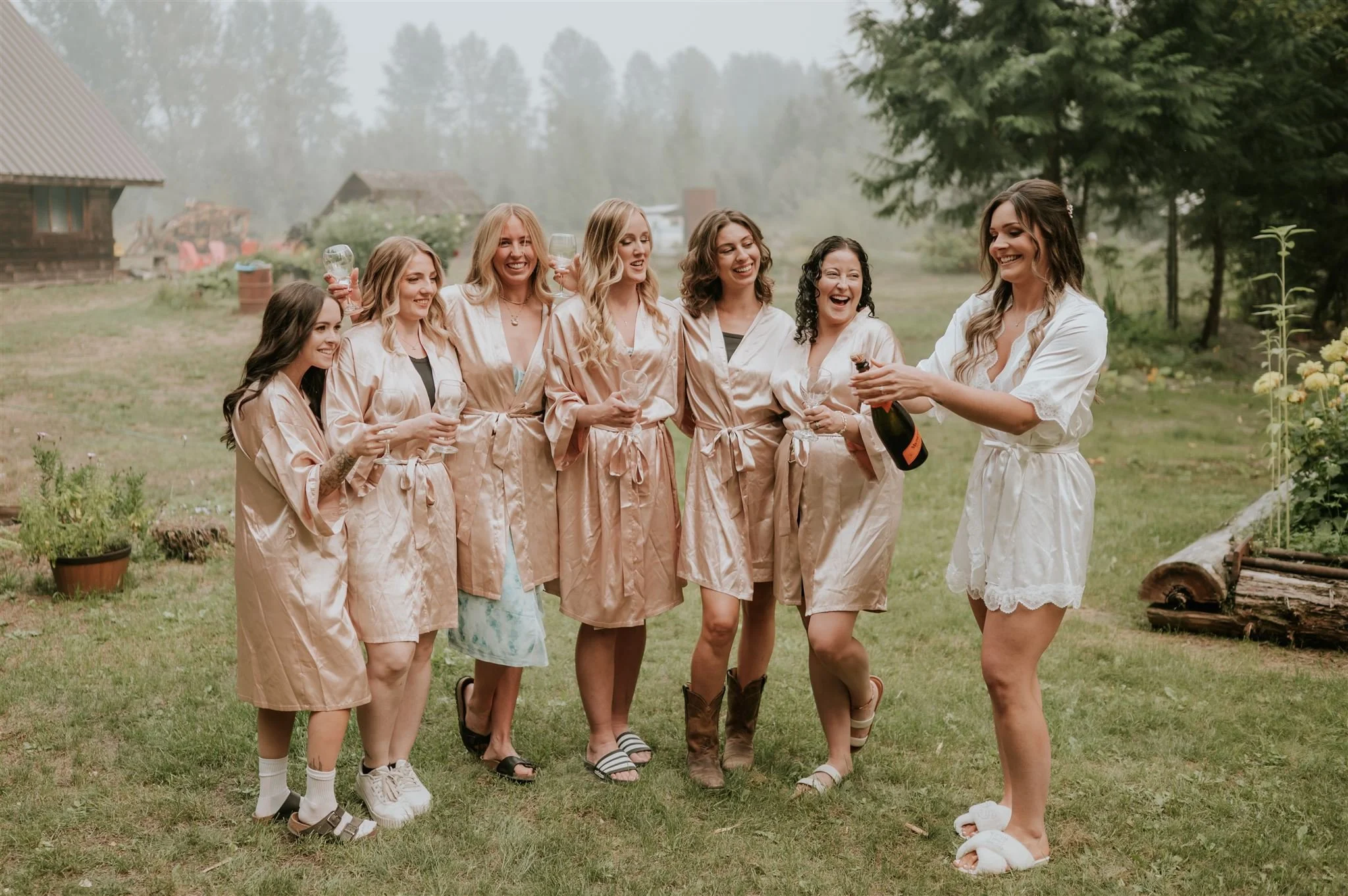 Bridesmaids in matching robes popping bubbles