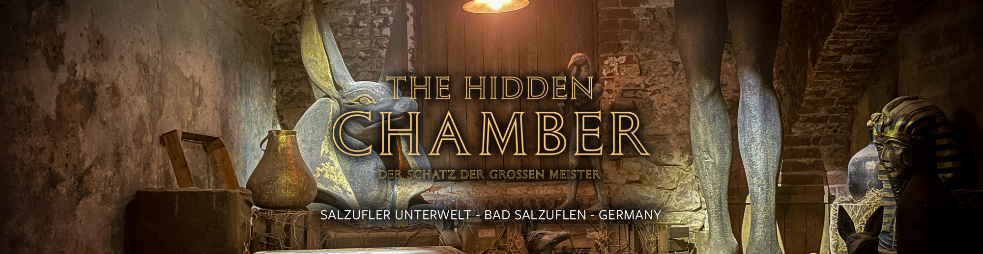 Exhibit in a museum with various artifacts, sculptures, and decorative items against brick walls, promoting 'The Hidden Chamber' at Salzfurter Unterwelt, Bad Salzufen, Germany.