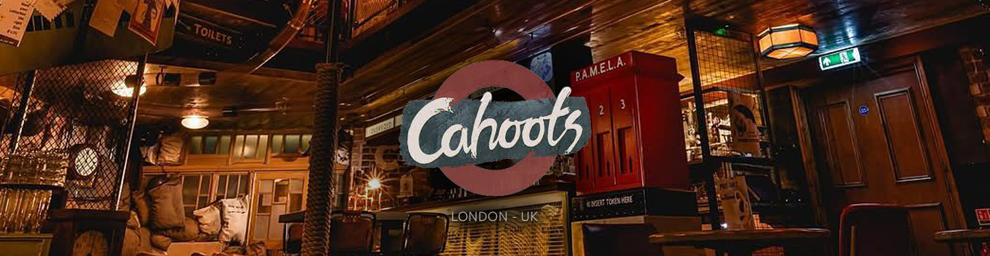 Interior of a cafe or restaurant with wooden decor, a sign reading 'Cahoots', and various furniture and fixtures.