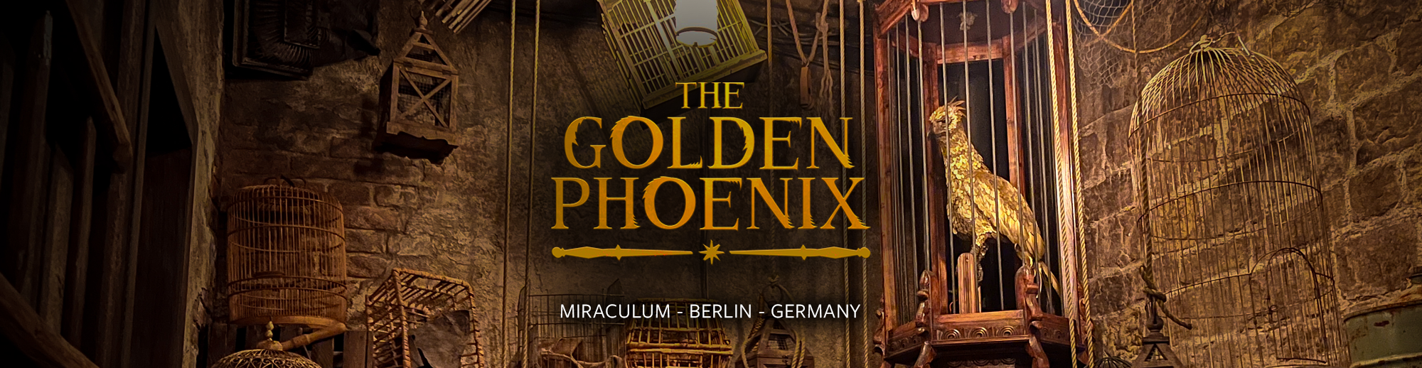 Interior of a museum exhibit featuring a large golden phoenix sculpture inside a cage, surrounded by birdcages and artifacts, with the title 'The Golden Phoenix' and location 'Miraculum - Berlin - Germany' displayed on the wall.