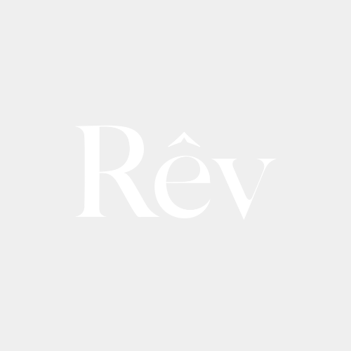The image features the word 'Rév' in large, white stylized letters on a light gray background.